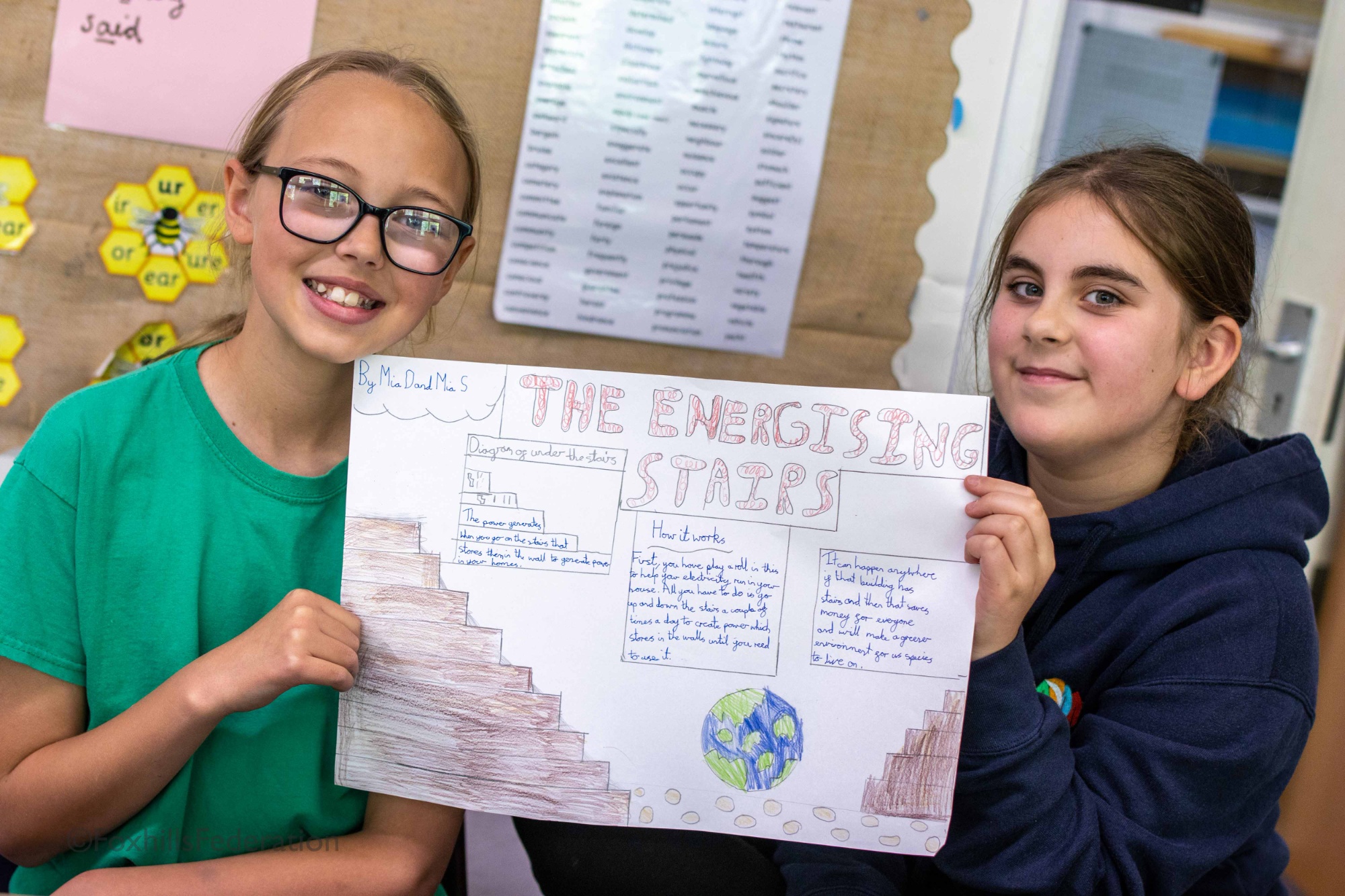 Two girls hold up their renewable energy idea