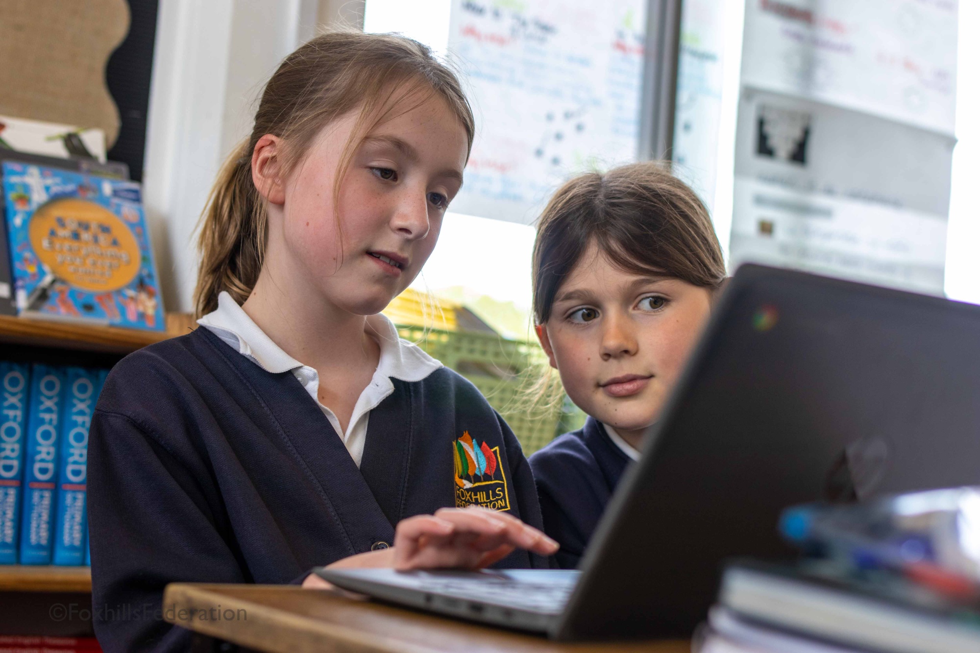 Two girls admire a spreadsheet