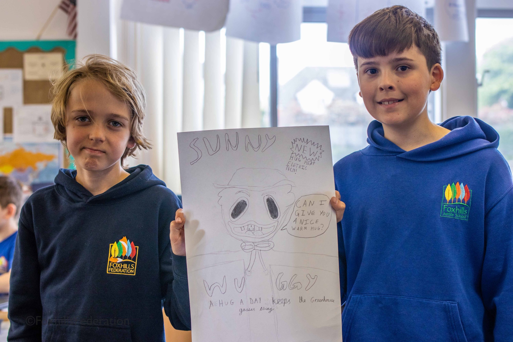 Two children hold up their renewable energy idea
