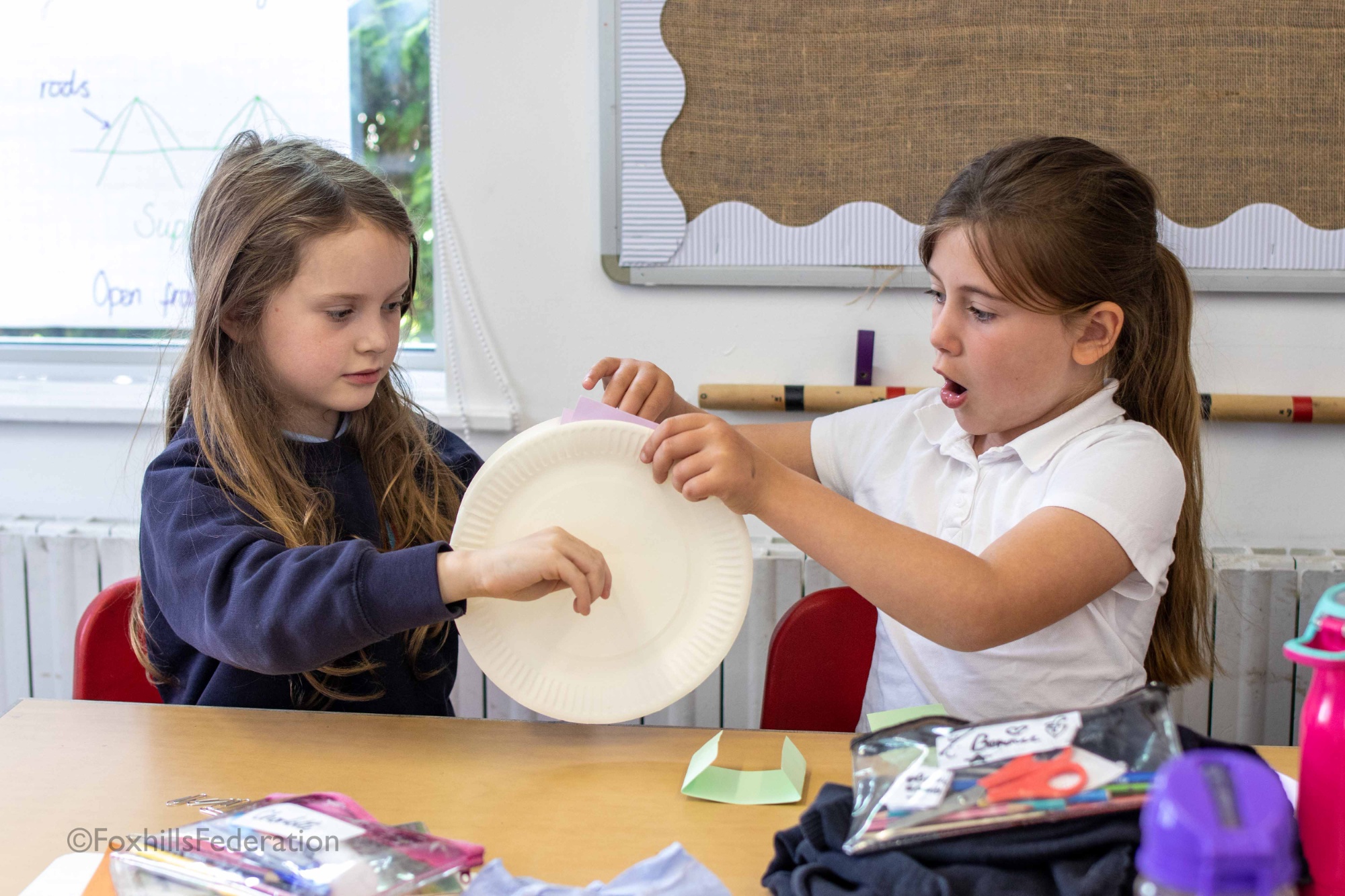 Two children make a water wheel