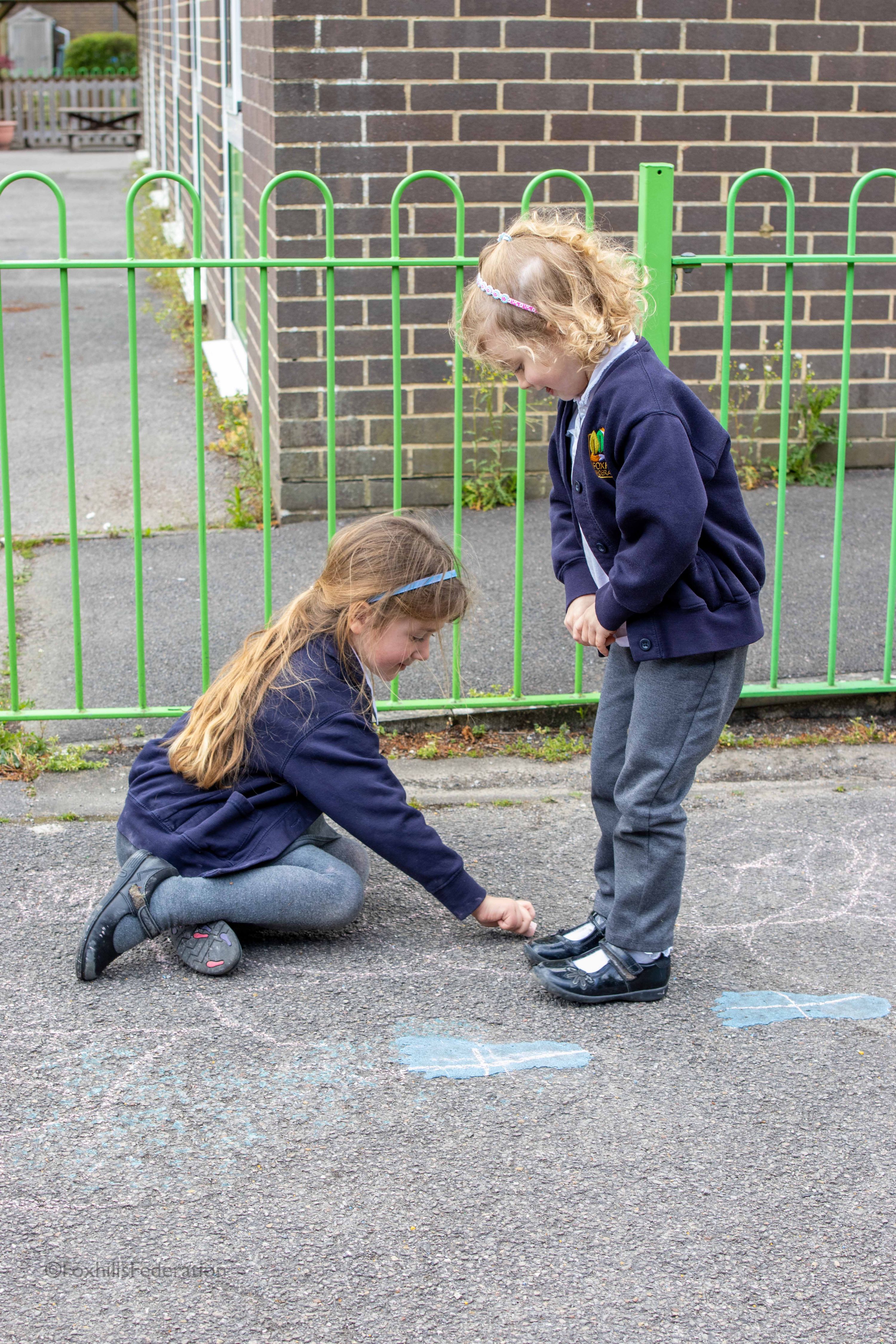 A Year R girl draws around another's shadow