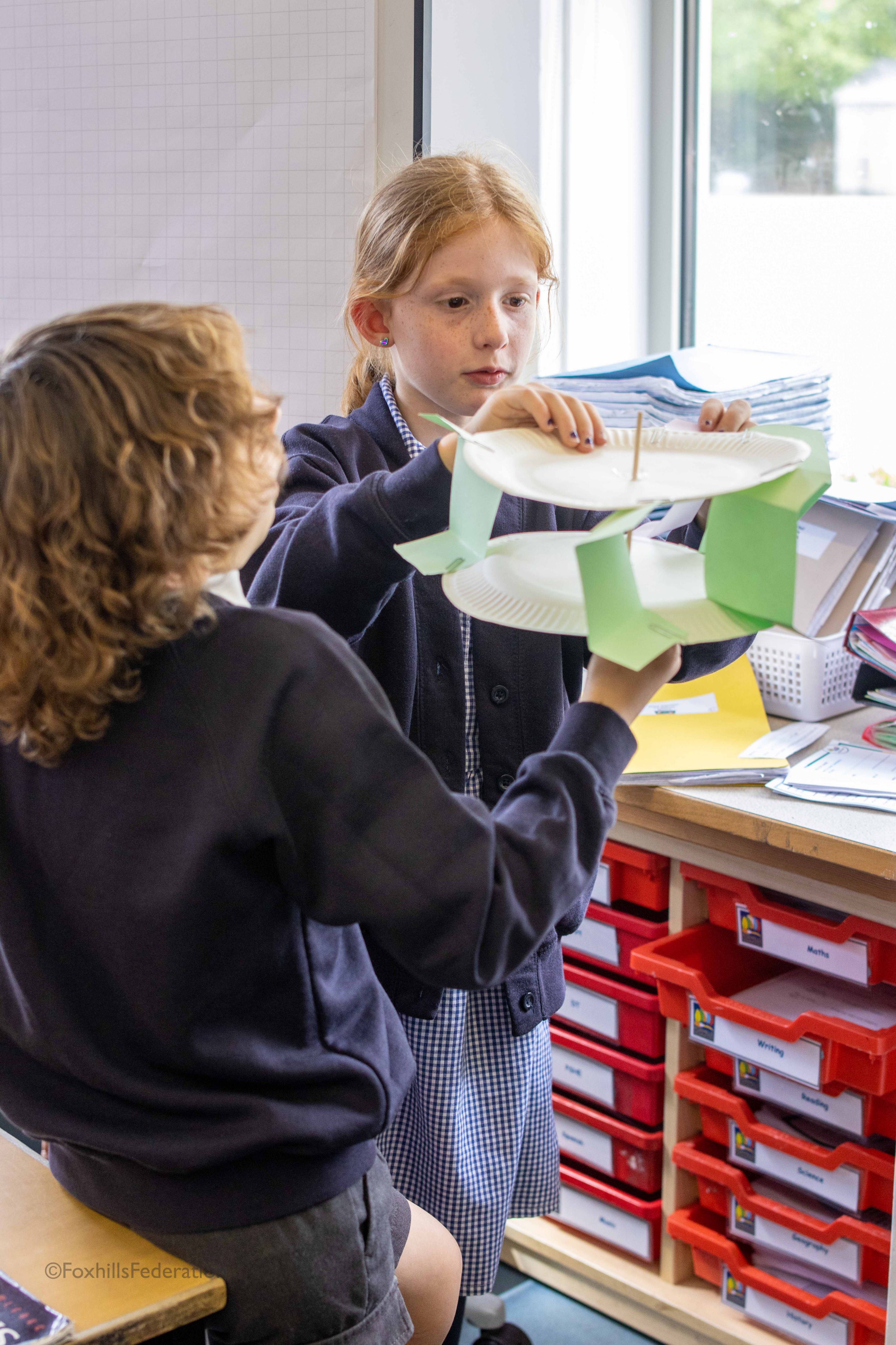 Two children make a water wheel