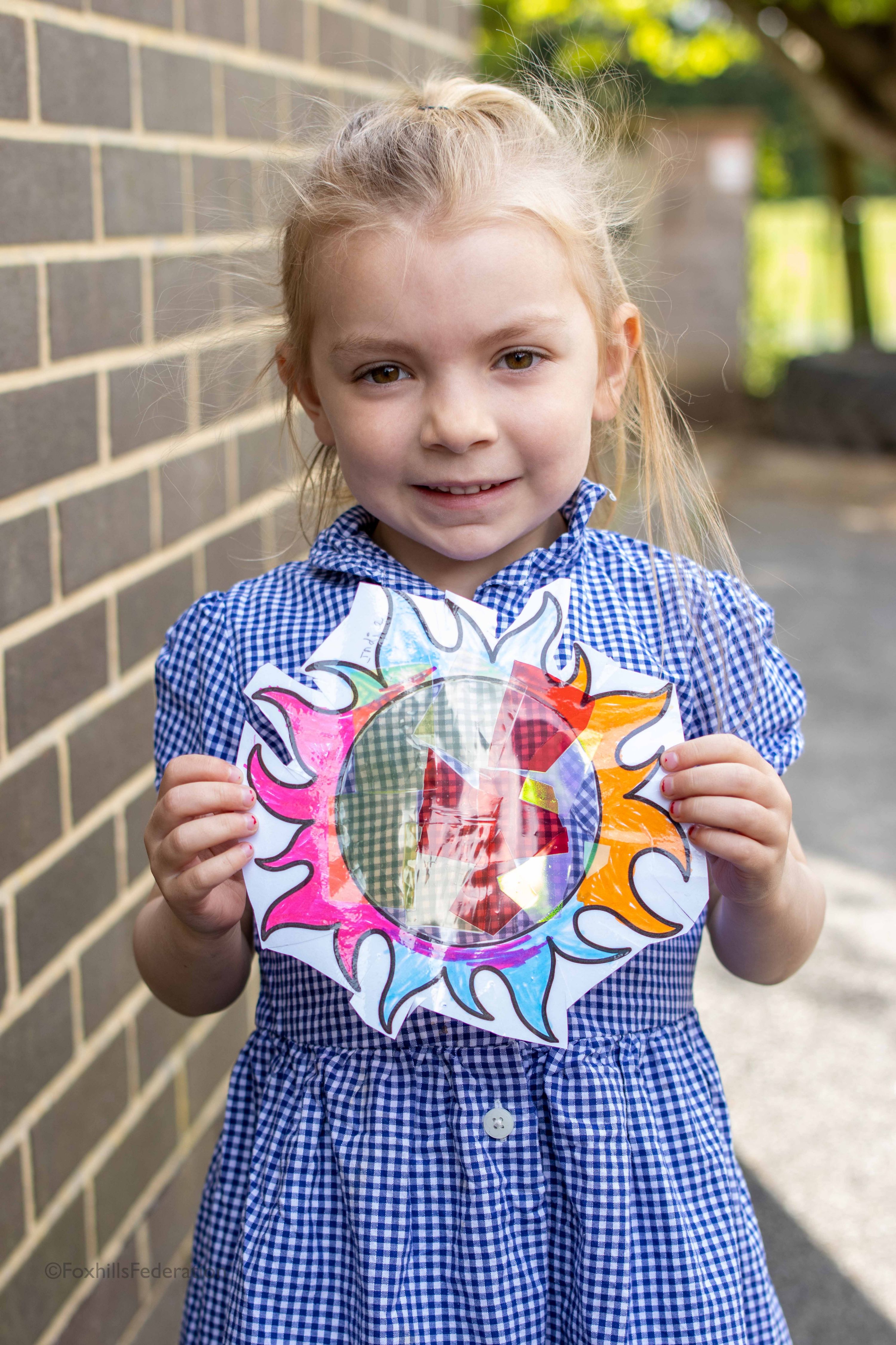 A girl holds her suncatcher