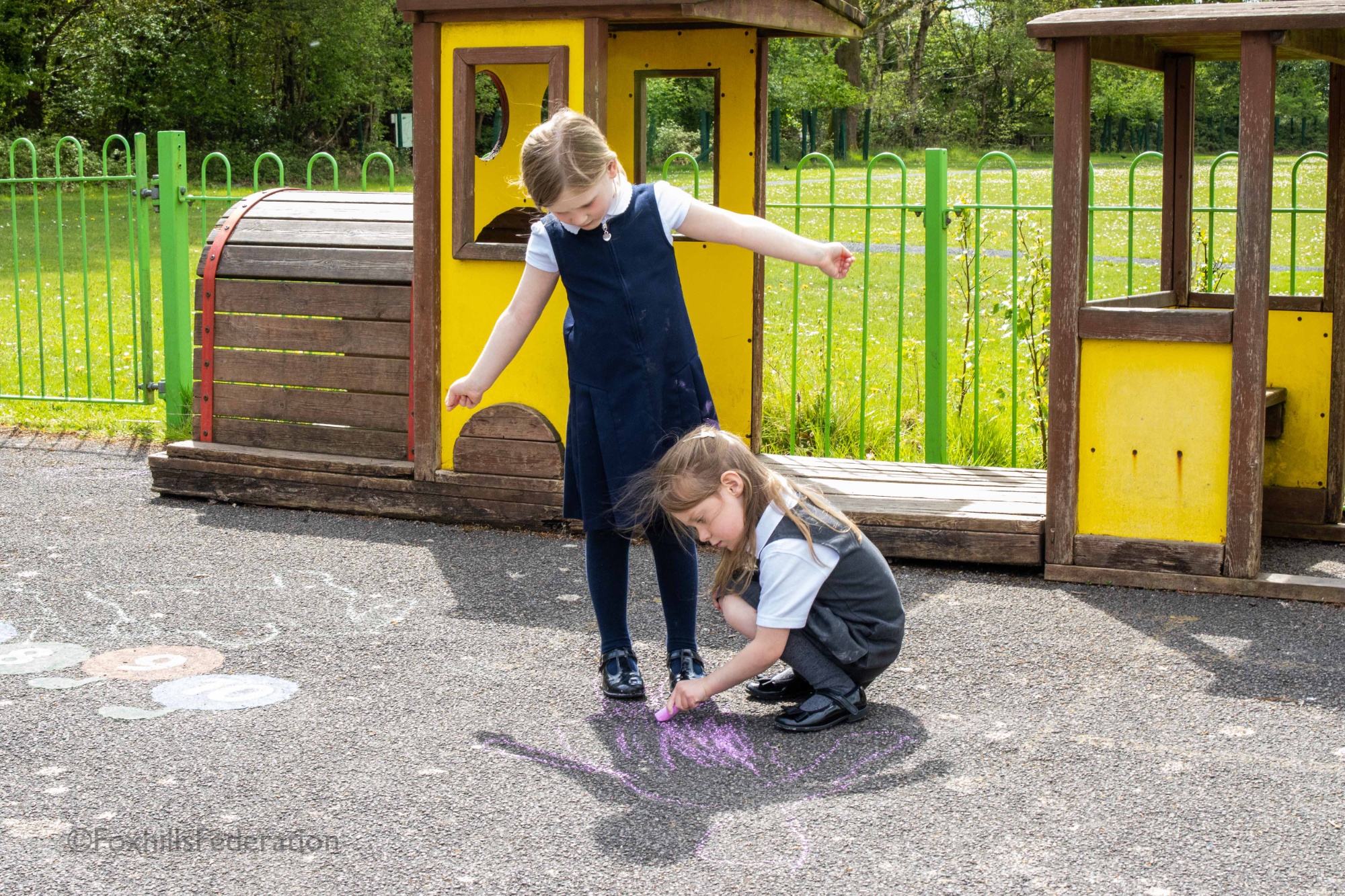 A Year R girl draws around another's shadow