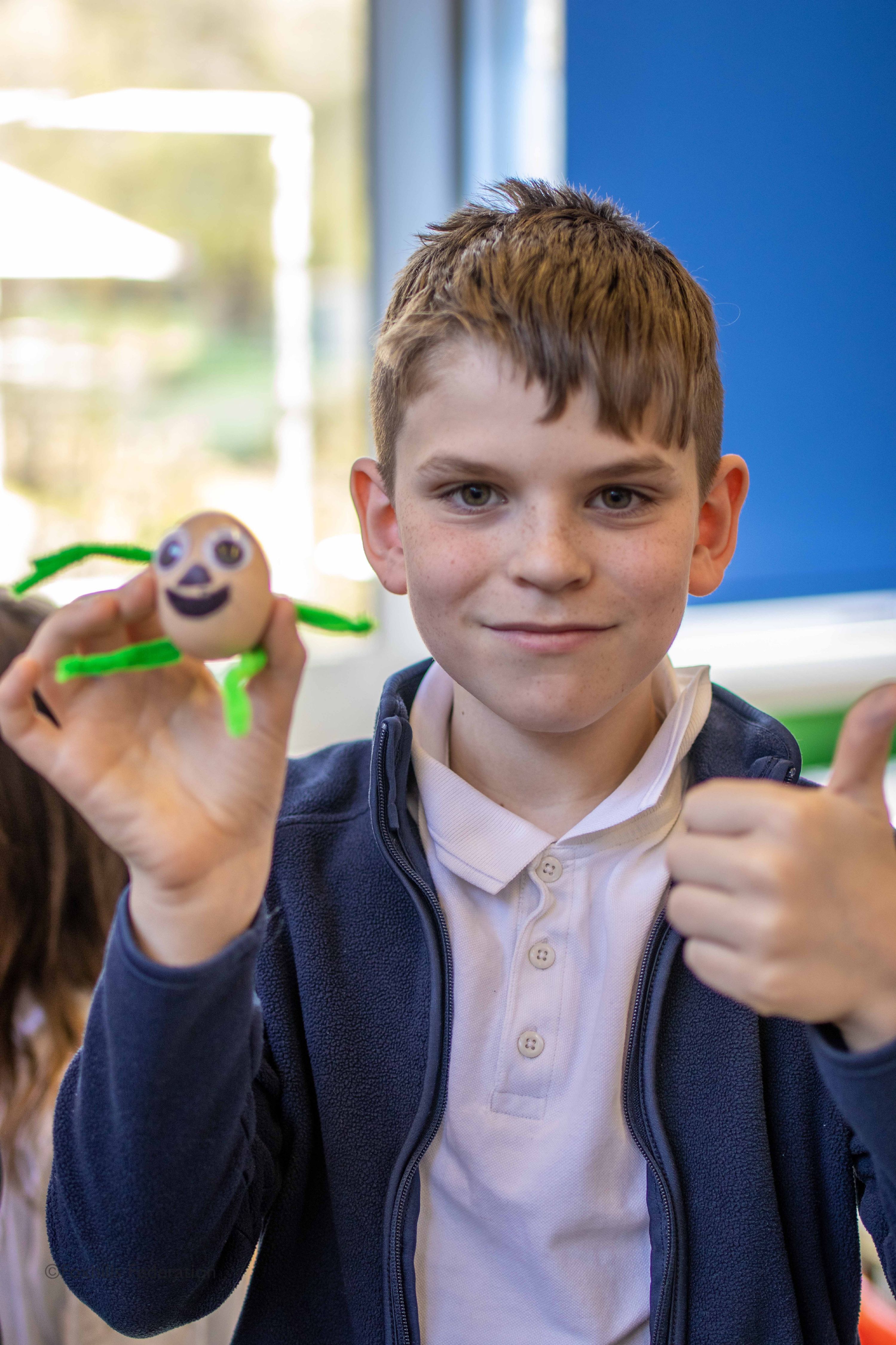 A boy holds a painted egg