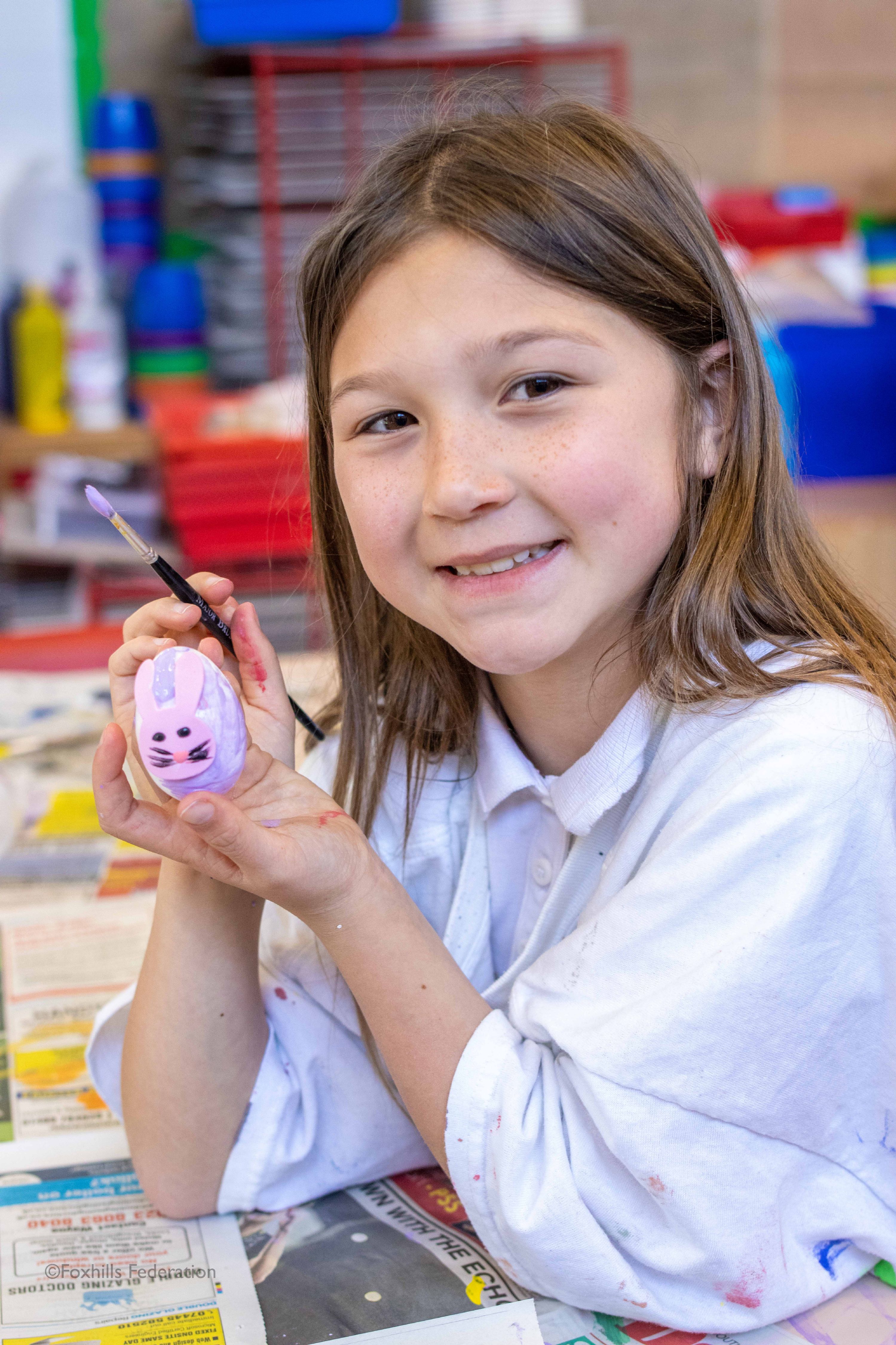 A girl paints a egg