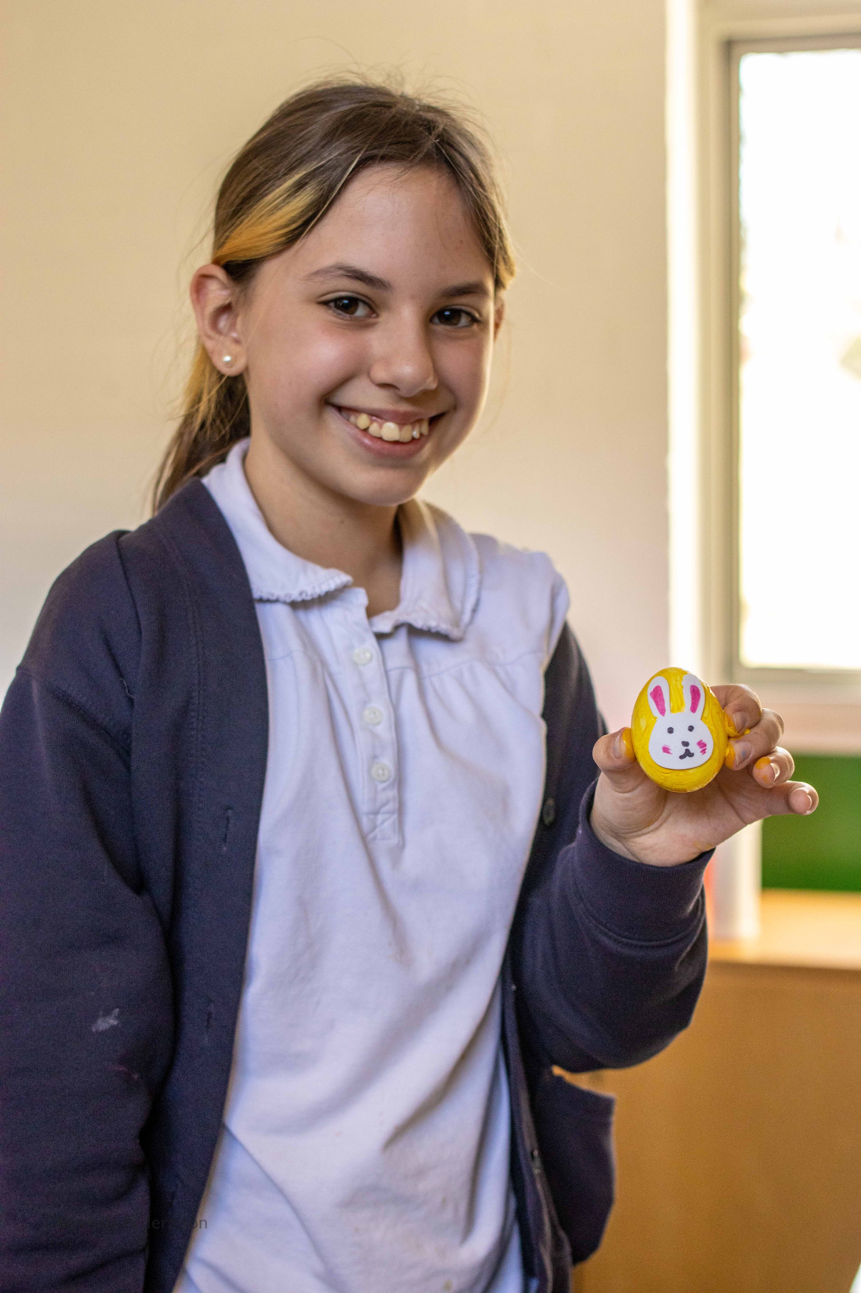 A girl holds a painted egg