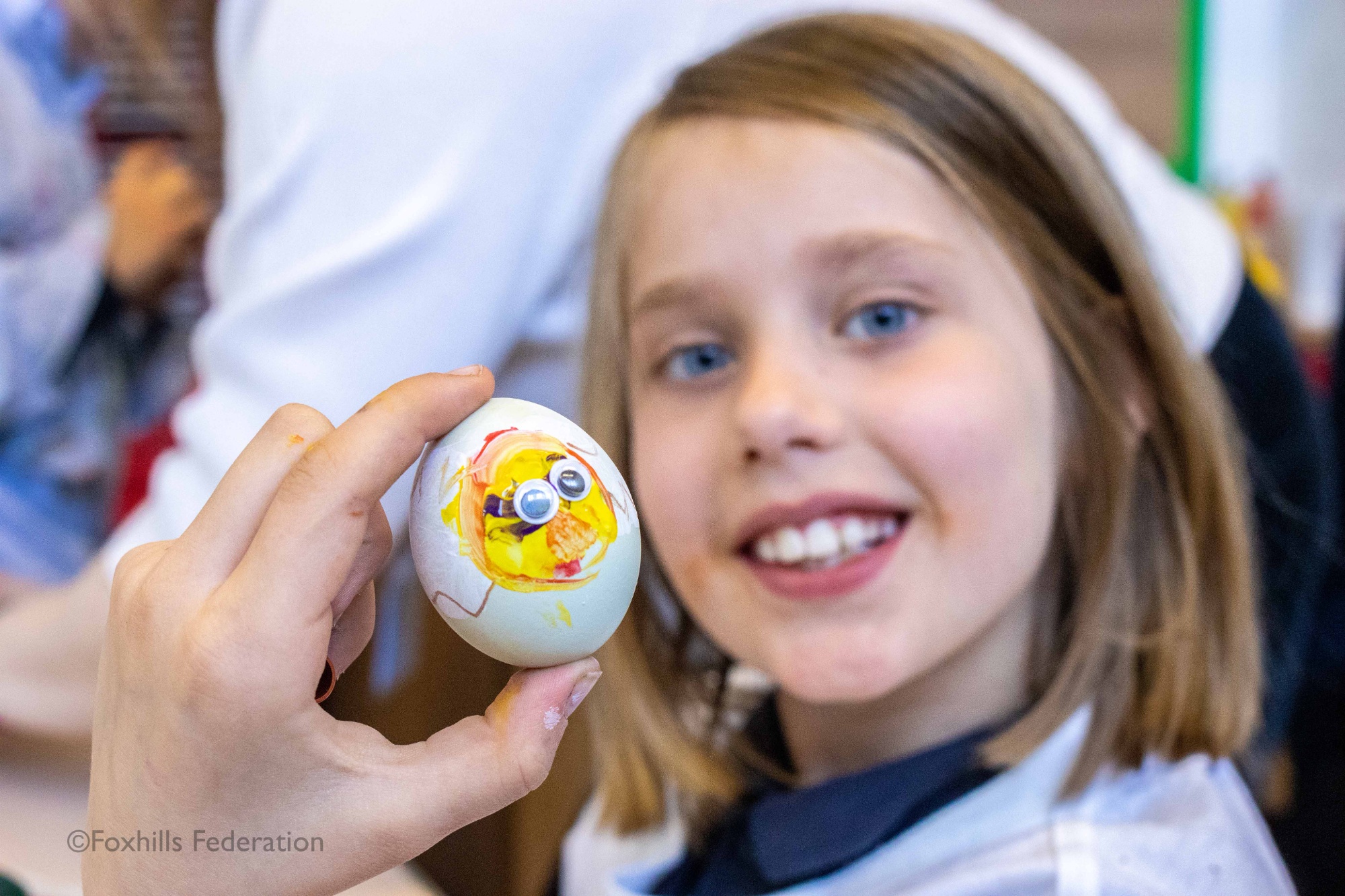 A girl holds a painted egg