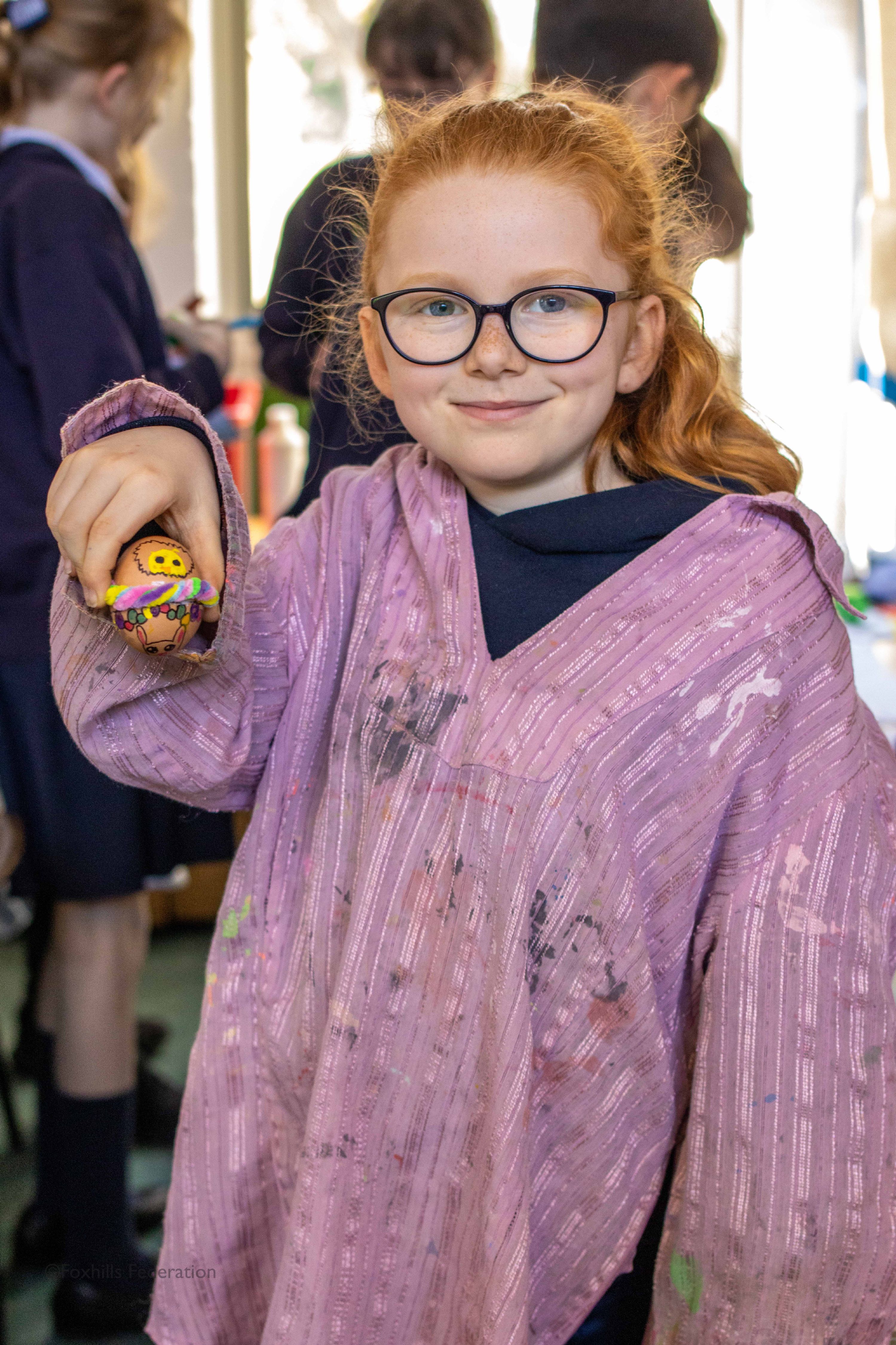 A girl holds a painted egg