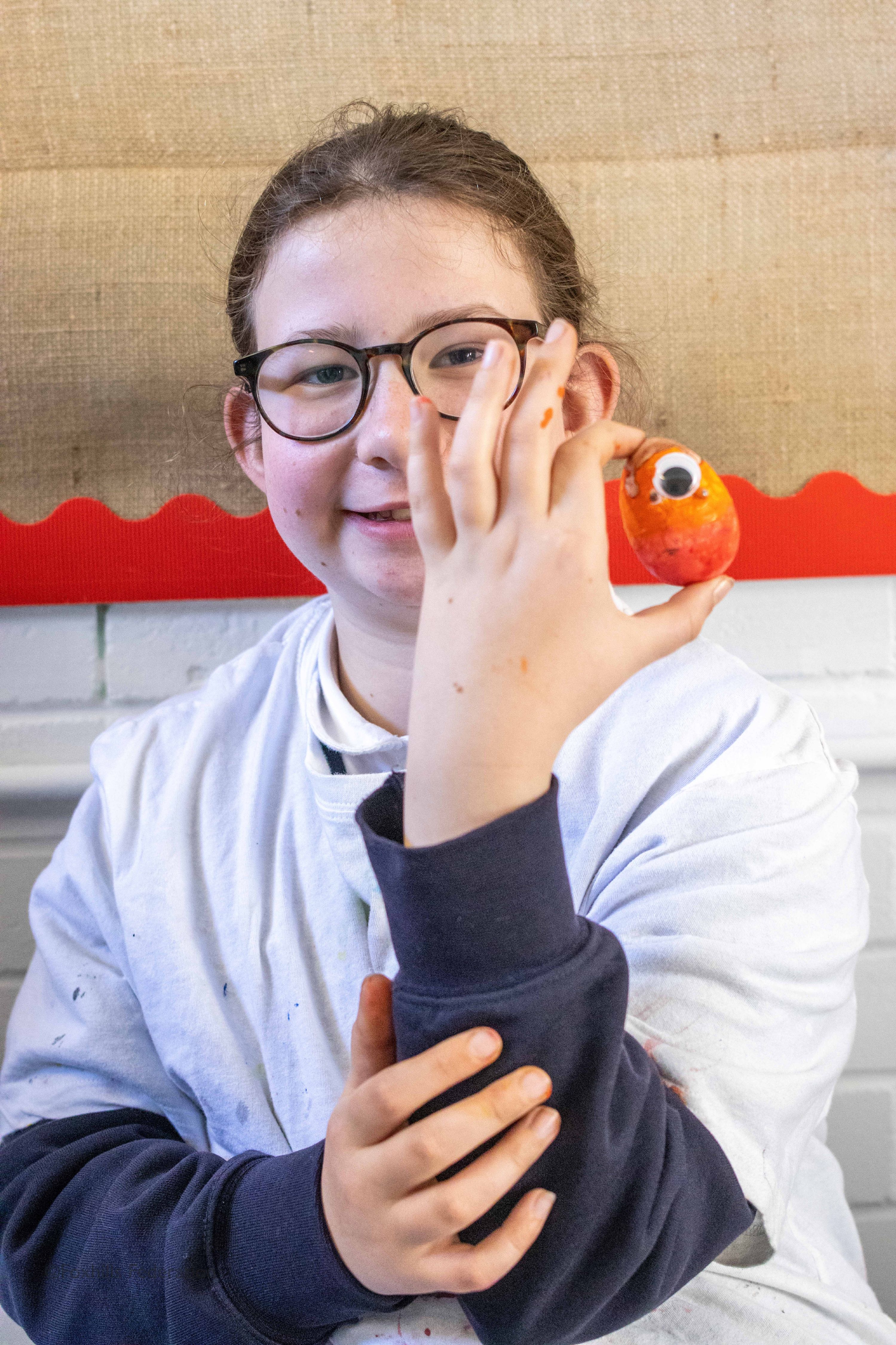 A girl holds a painted egg