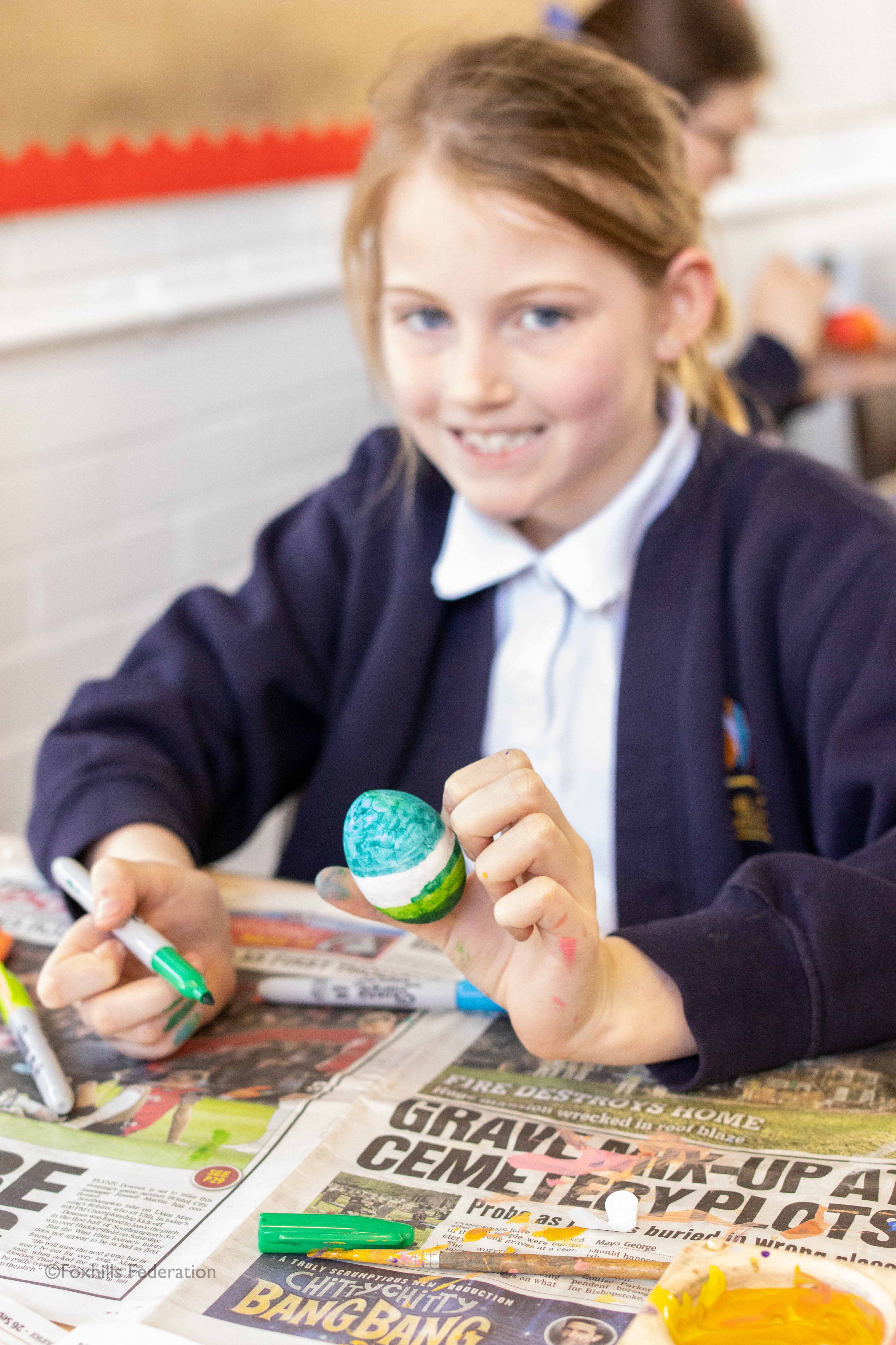 A girl holds a painted egg