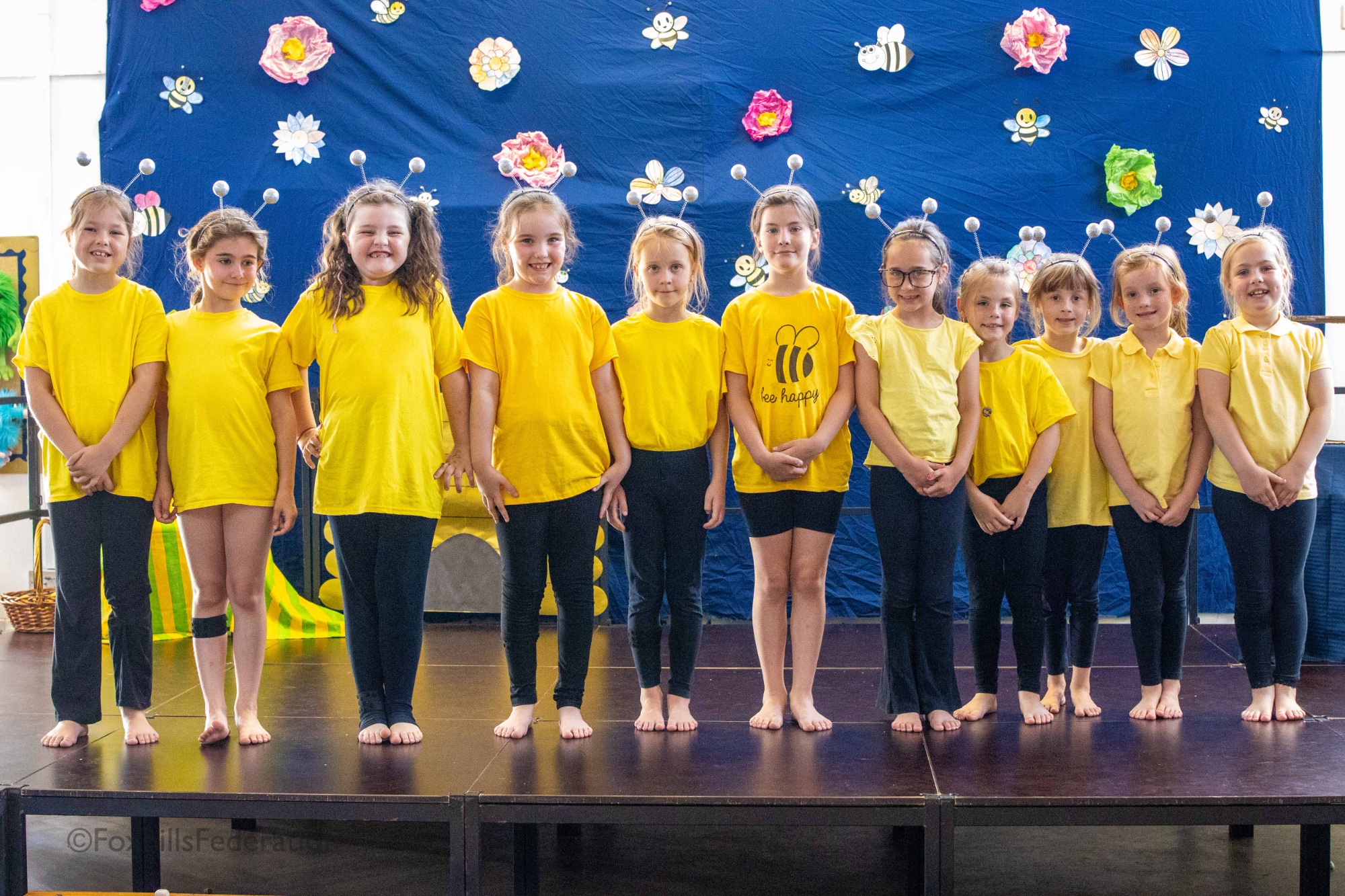A group of children dressed as bees pose