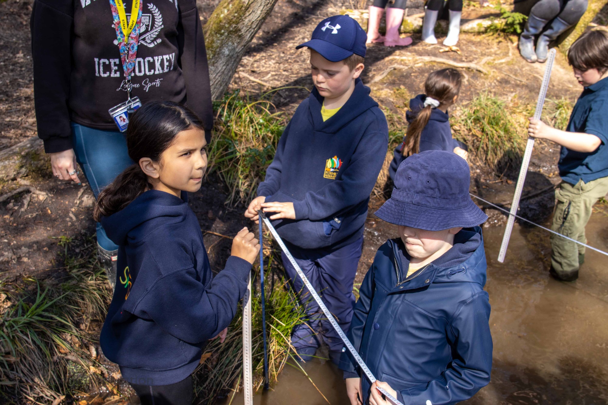 Children measure the depth of a stream