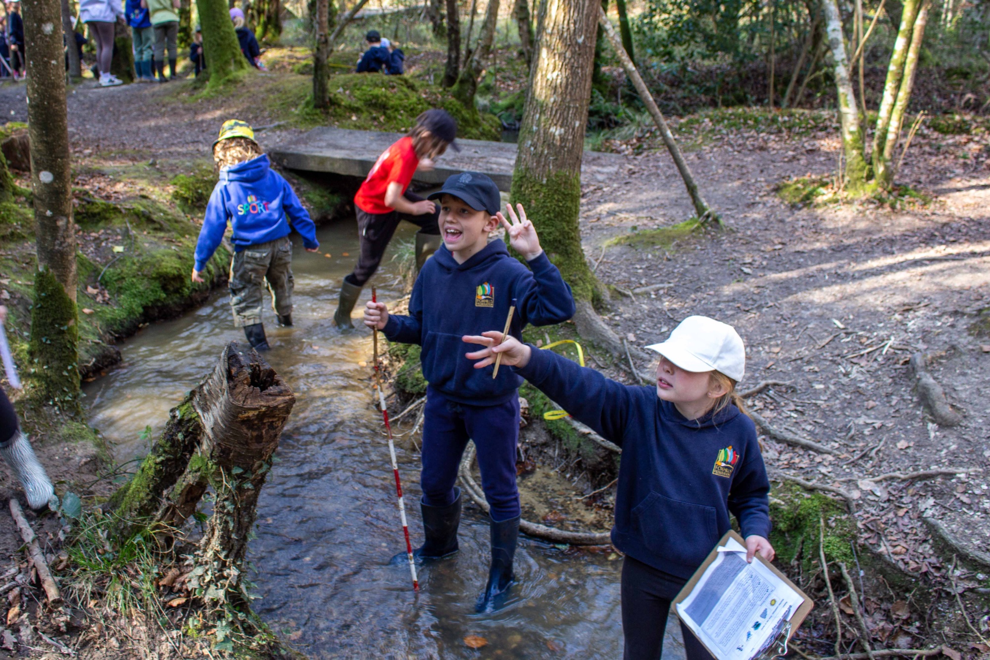 Children measure the depth of a stream