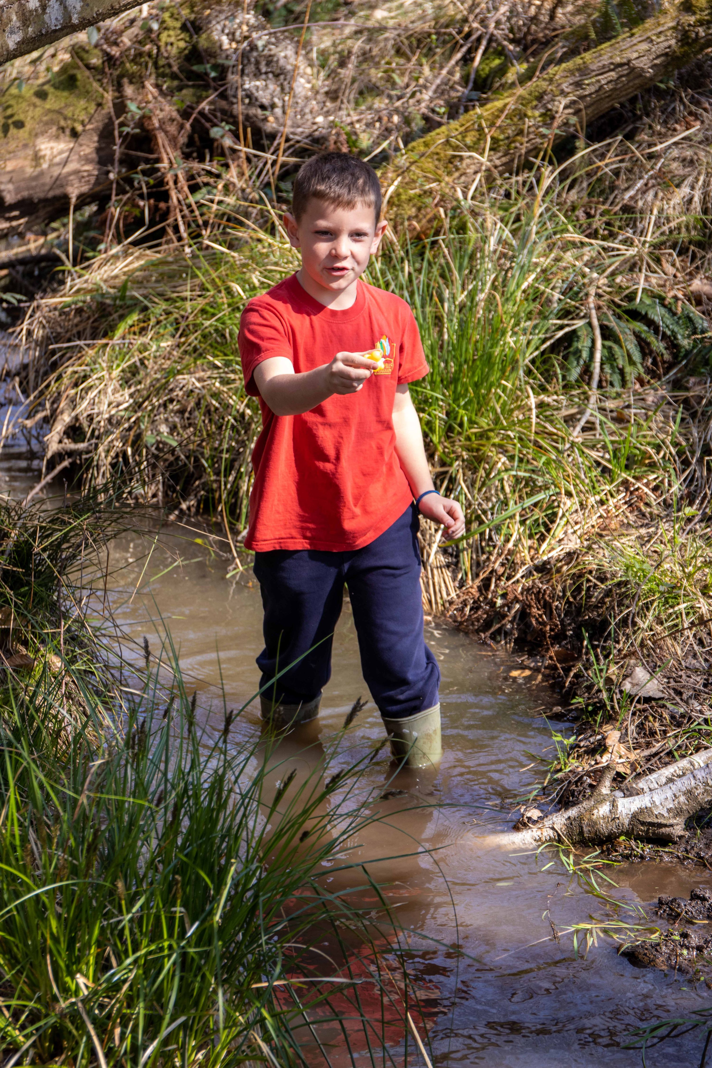A boy holds a rubber duck about to test the speed of the water