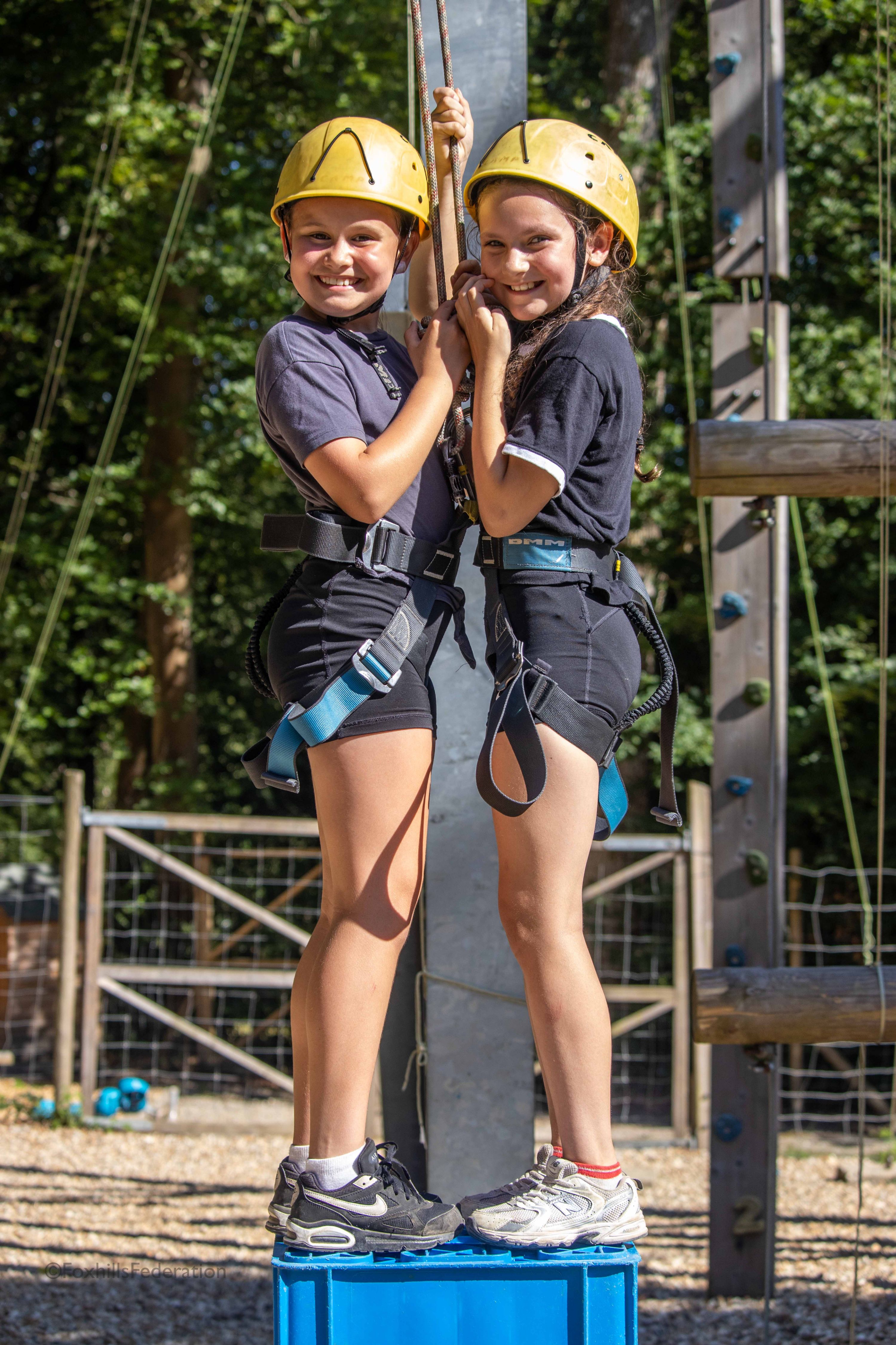 Two girls stand on top of crates
