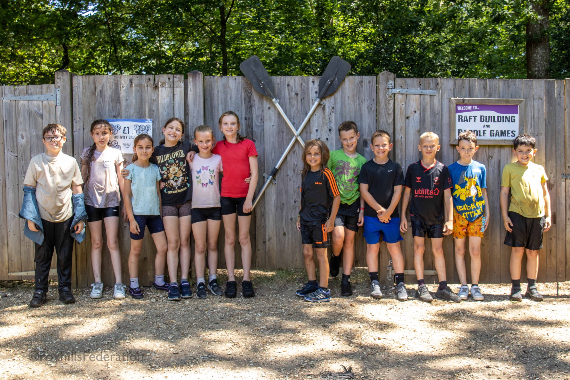 A group of children stand soaked after raft building