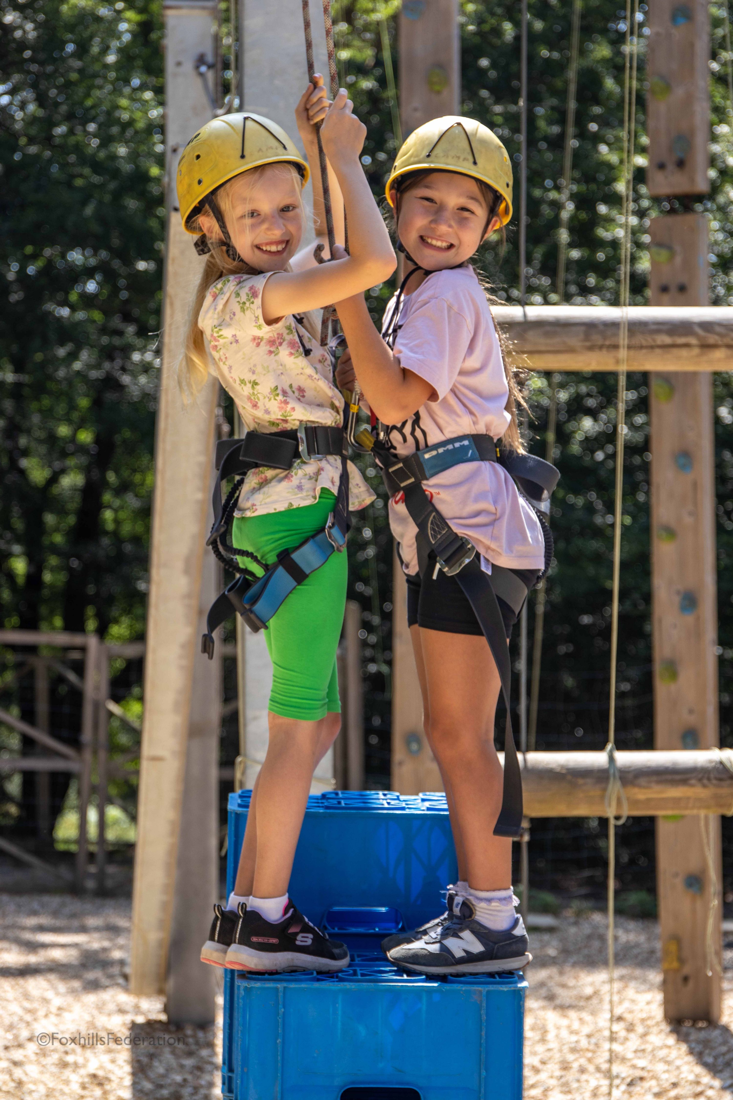 Two girls stand on stacked crates