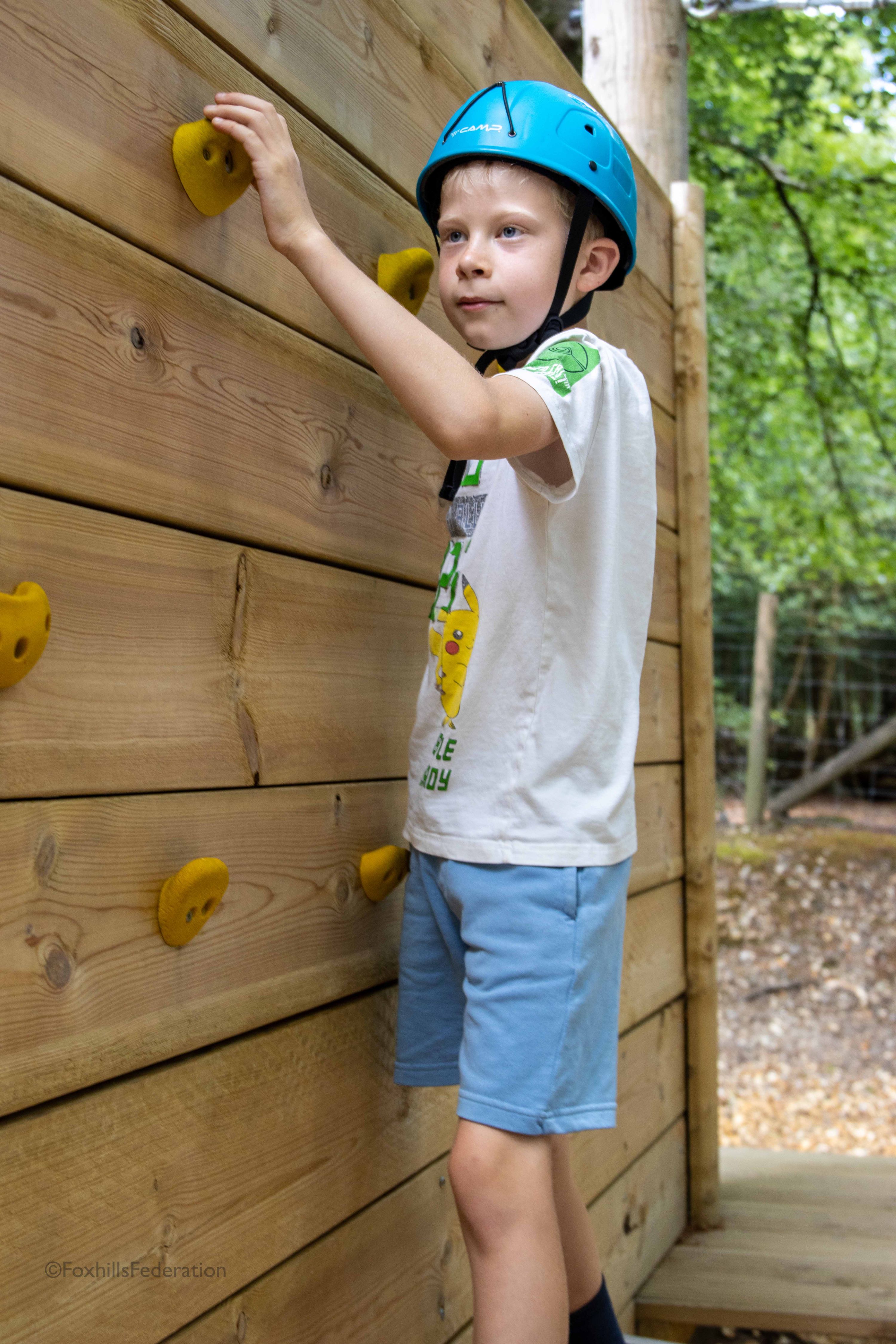 A boys climbs on a rock wall