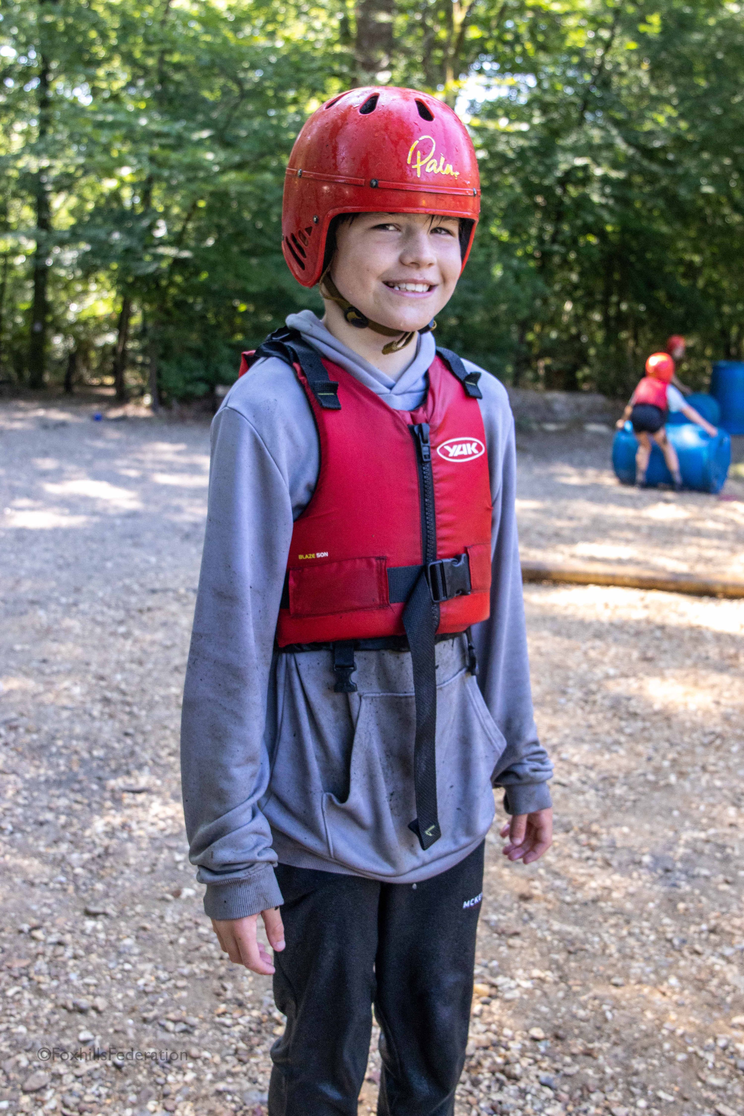 A boy in safety kits smiles