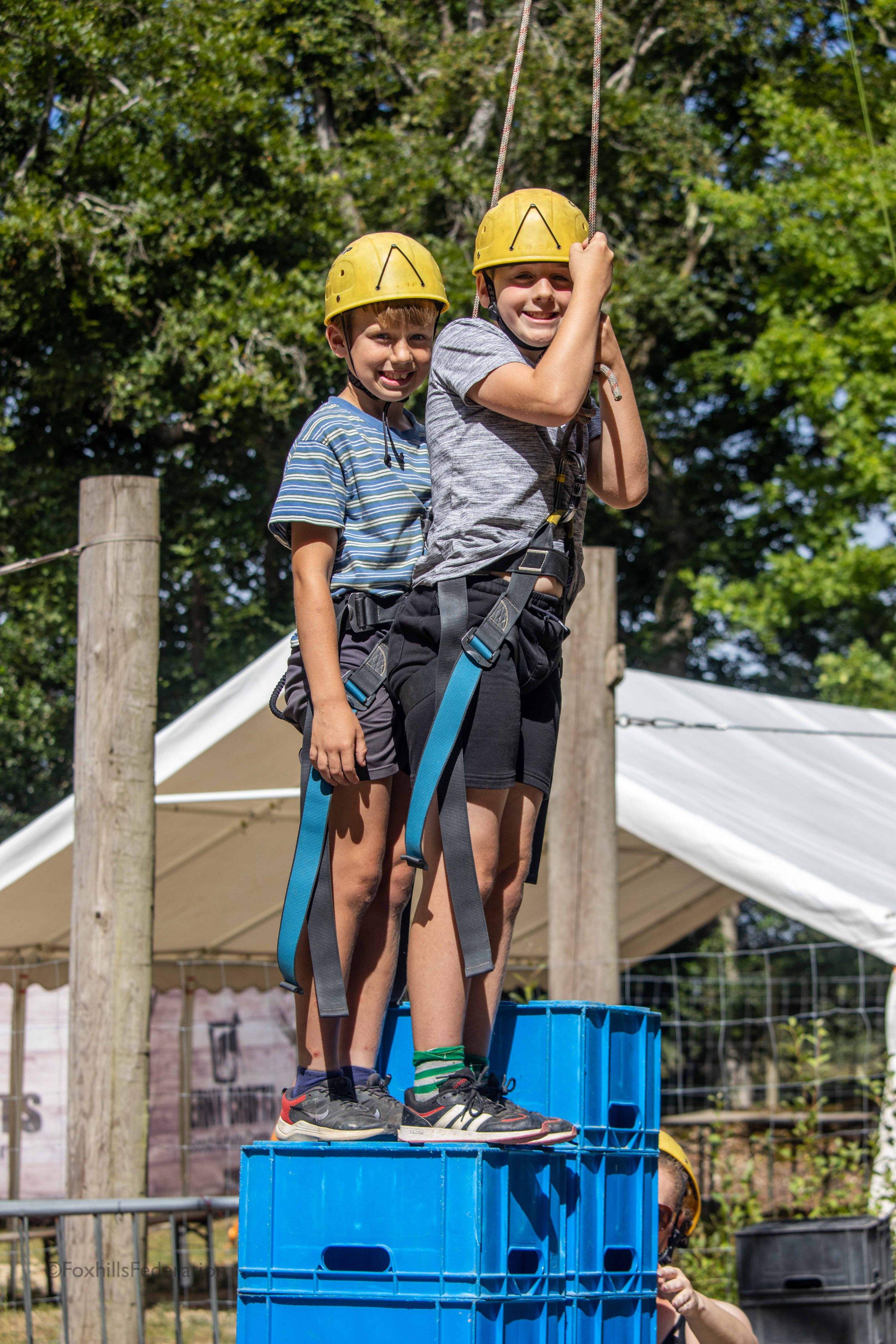 Two boys stand on top of stacked crates