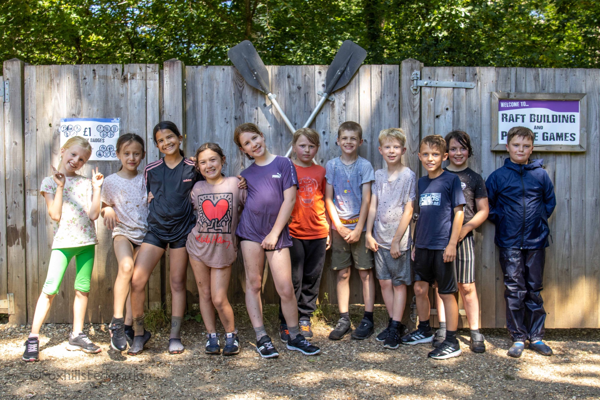A group of wet children stand after raft building