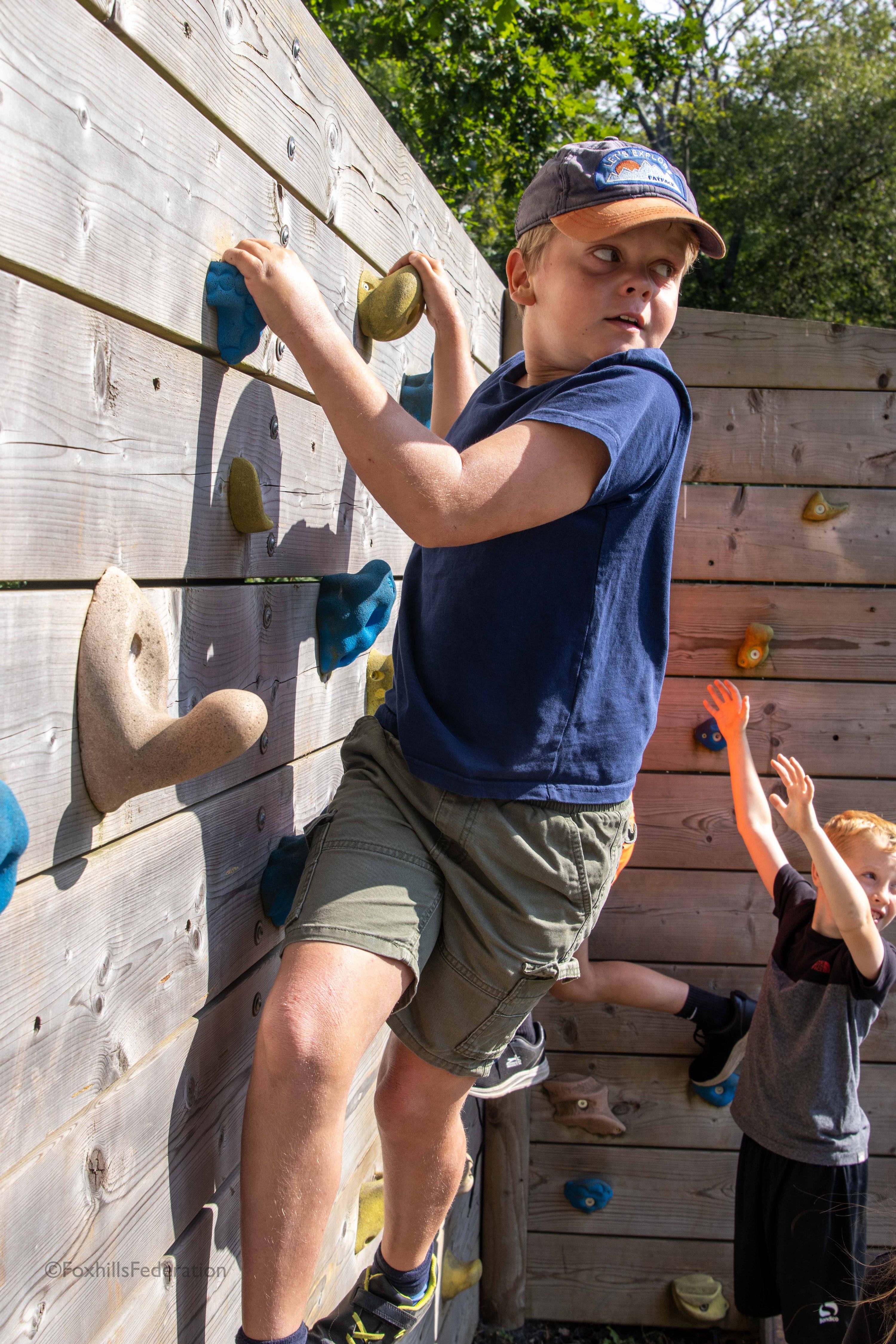 A boy climbs on a rock wall