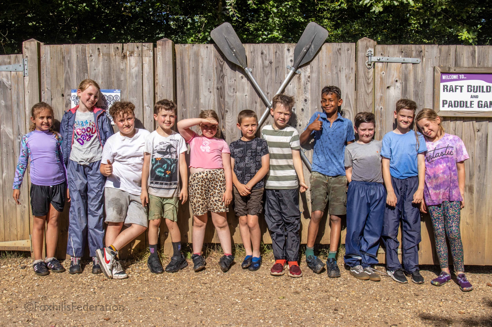 A group of children smile to the camera after raft building