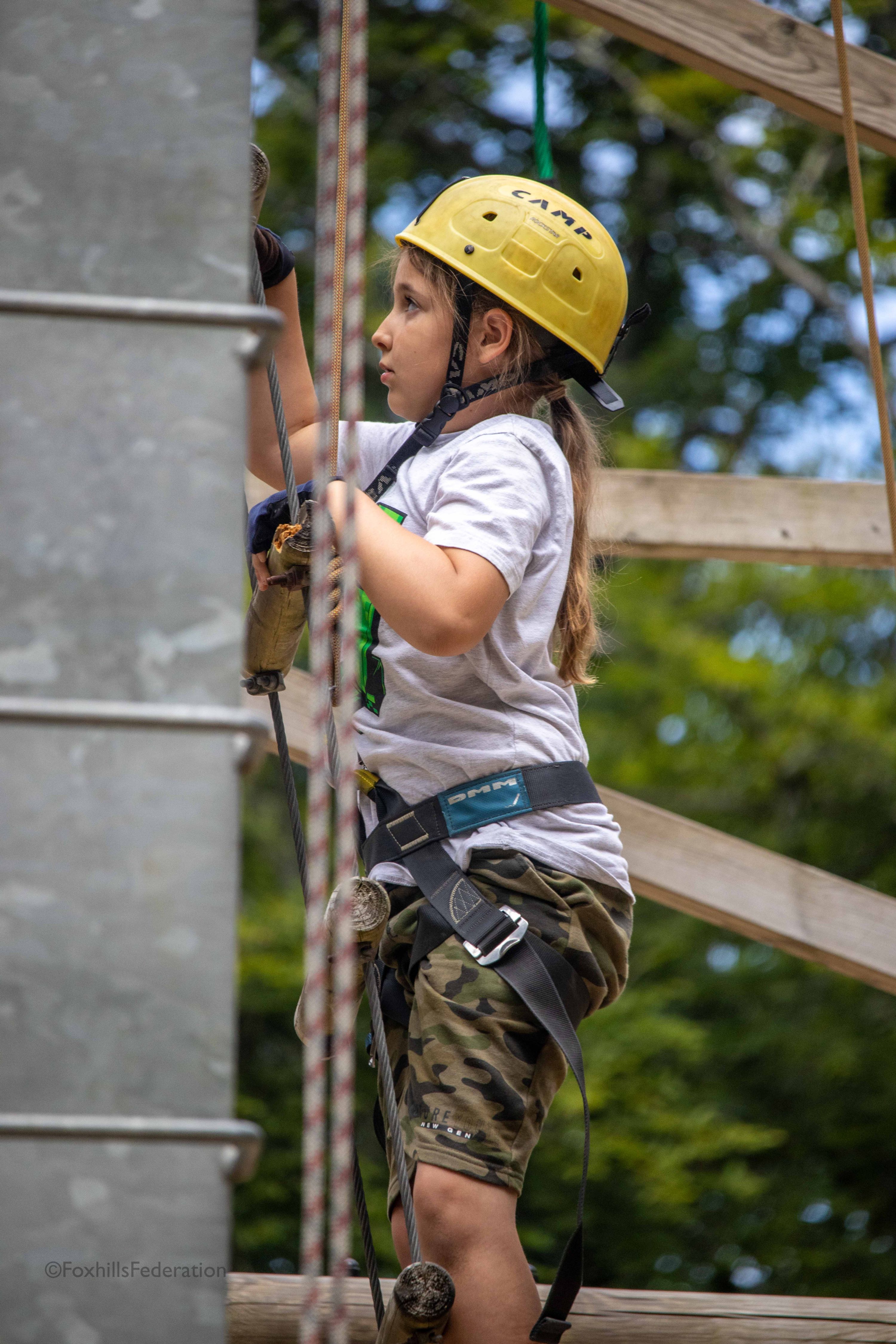 A girl climbs a ladder