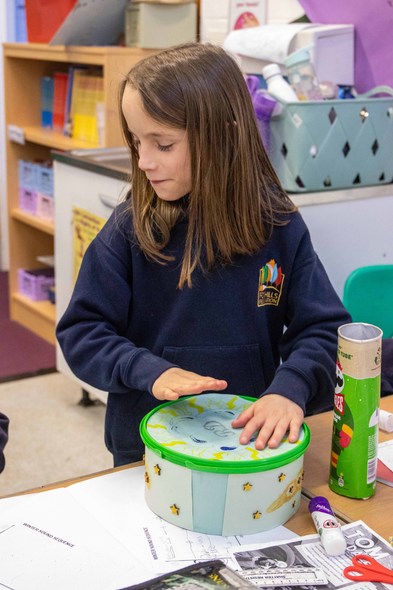 A boy plays a homemade music instrument.