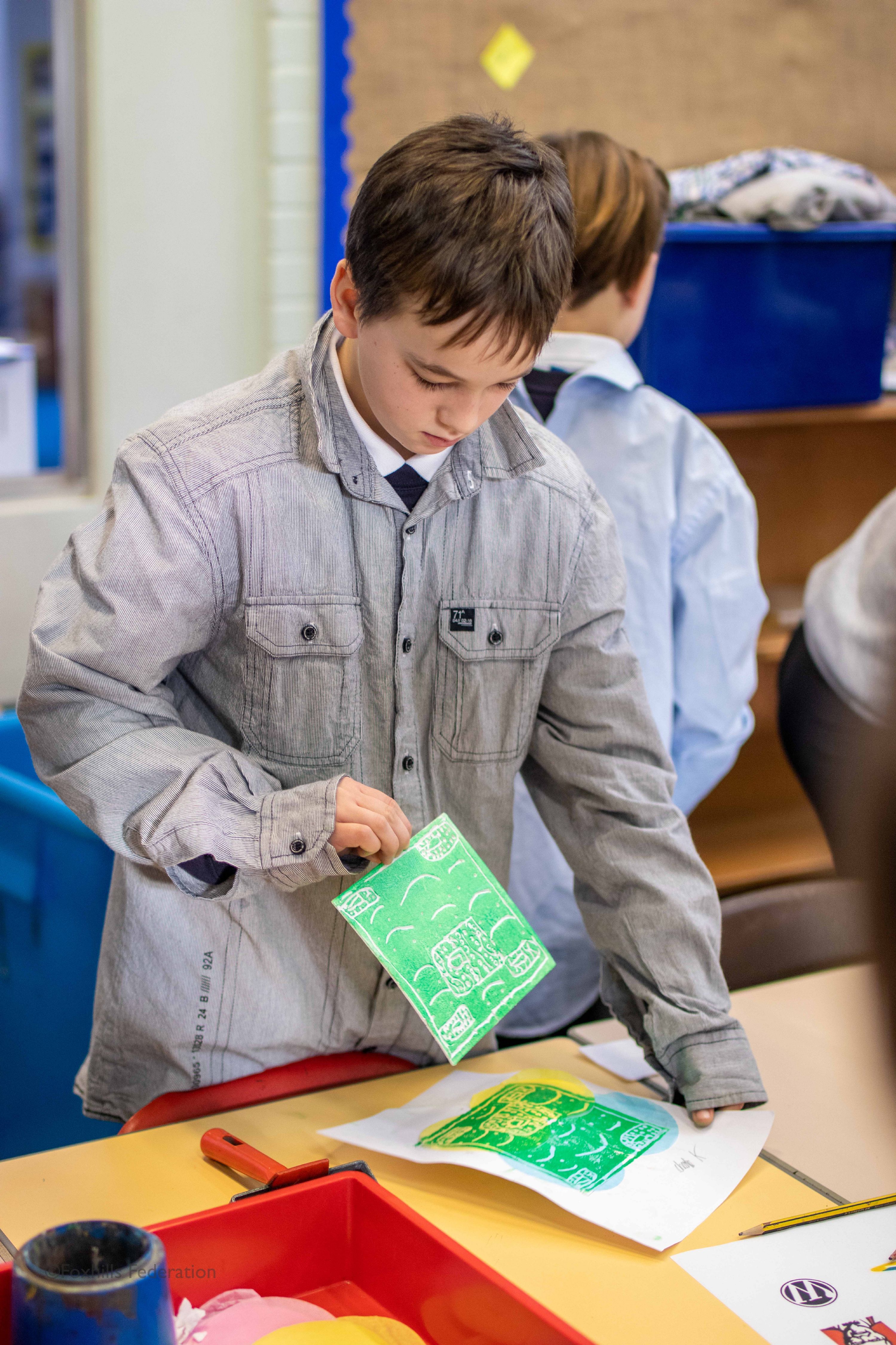 A boy creates work with stamp printing.