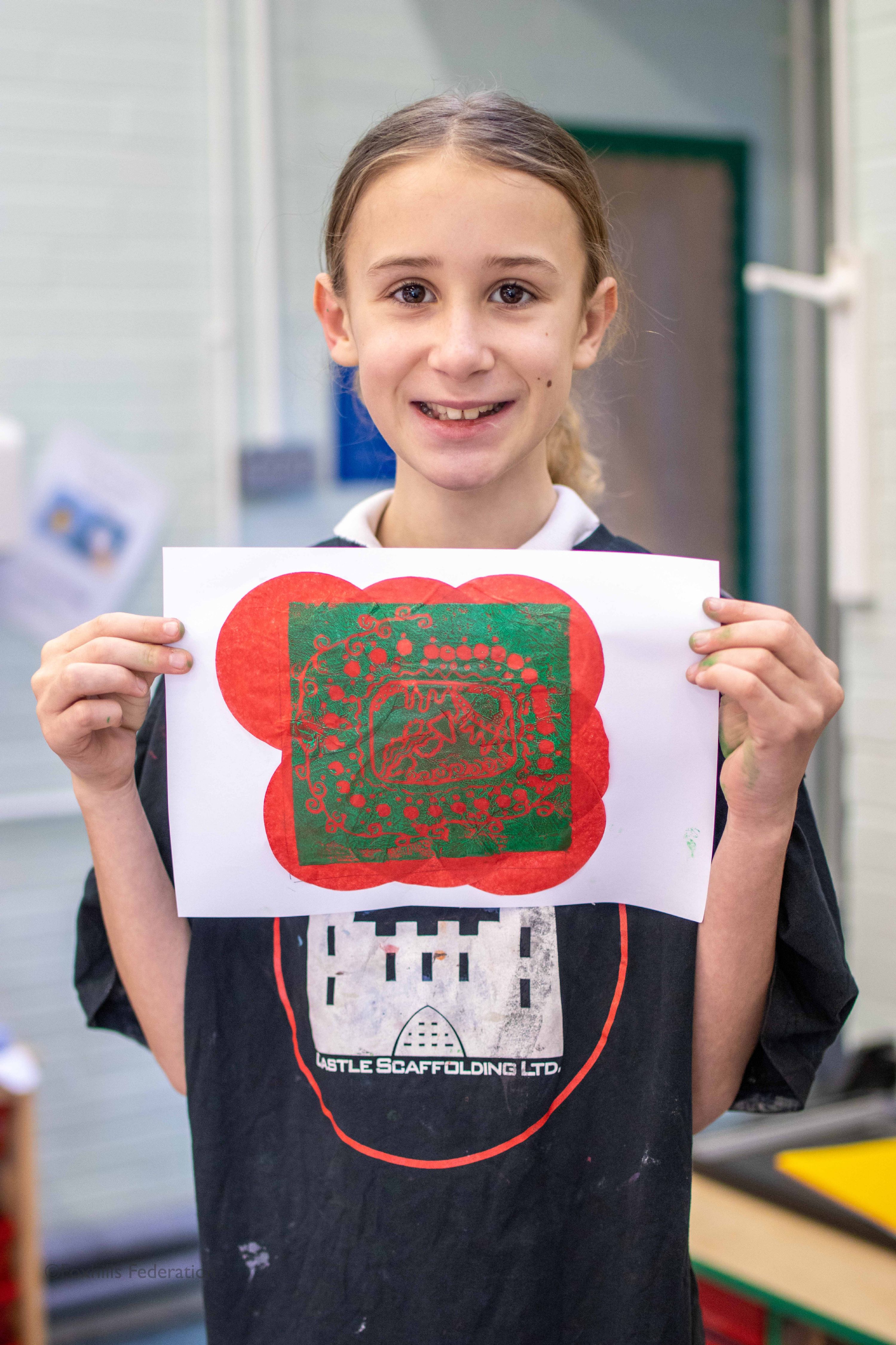 A girl holds up work created by stamp printing.
