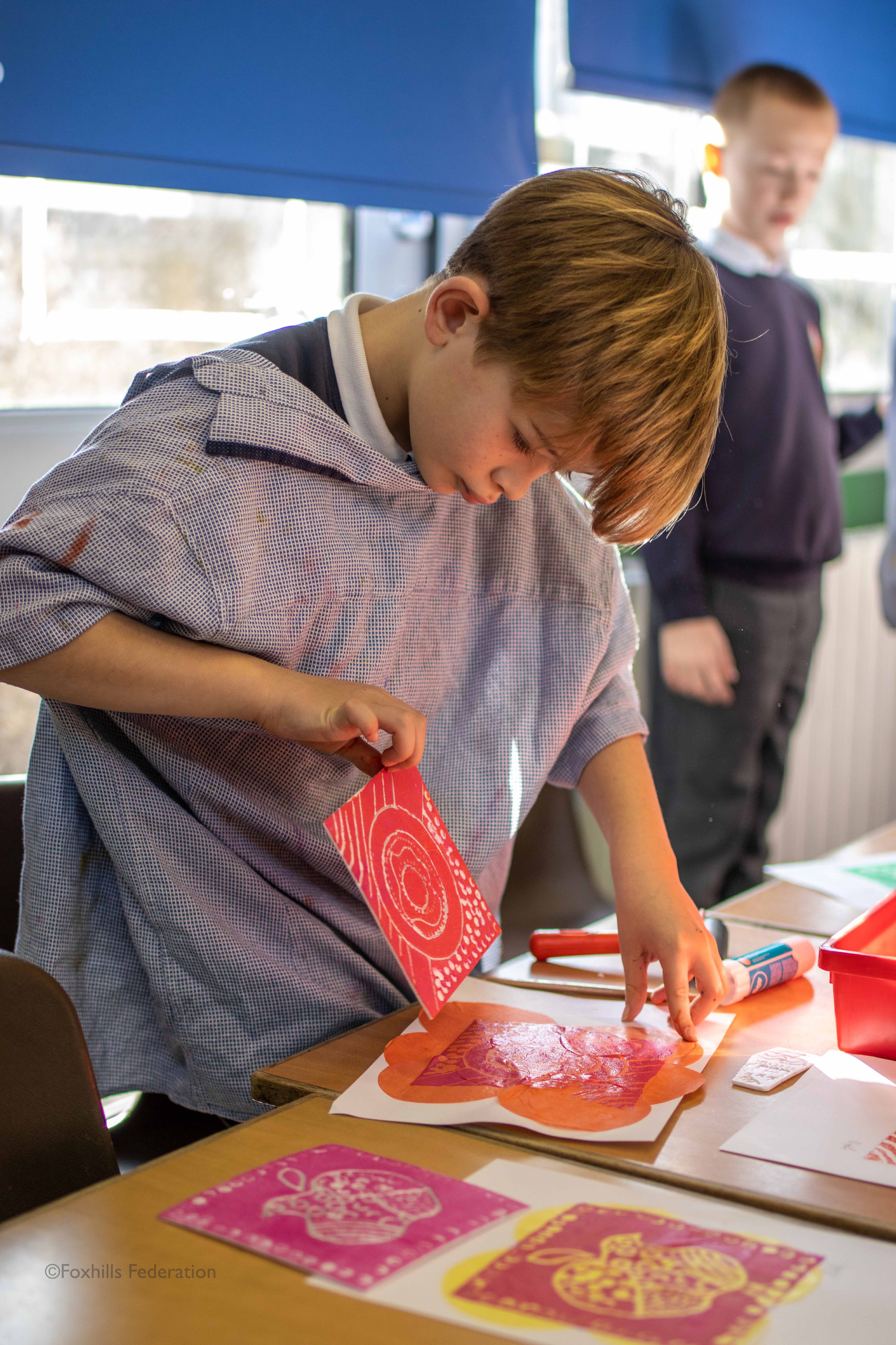 A boy creates work with stamp printing.