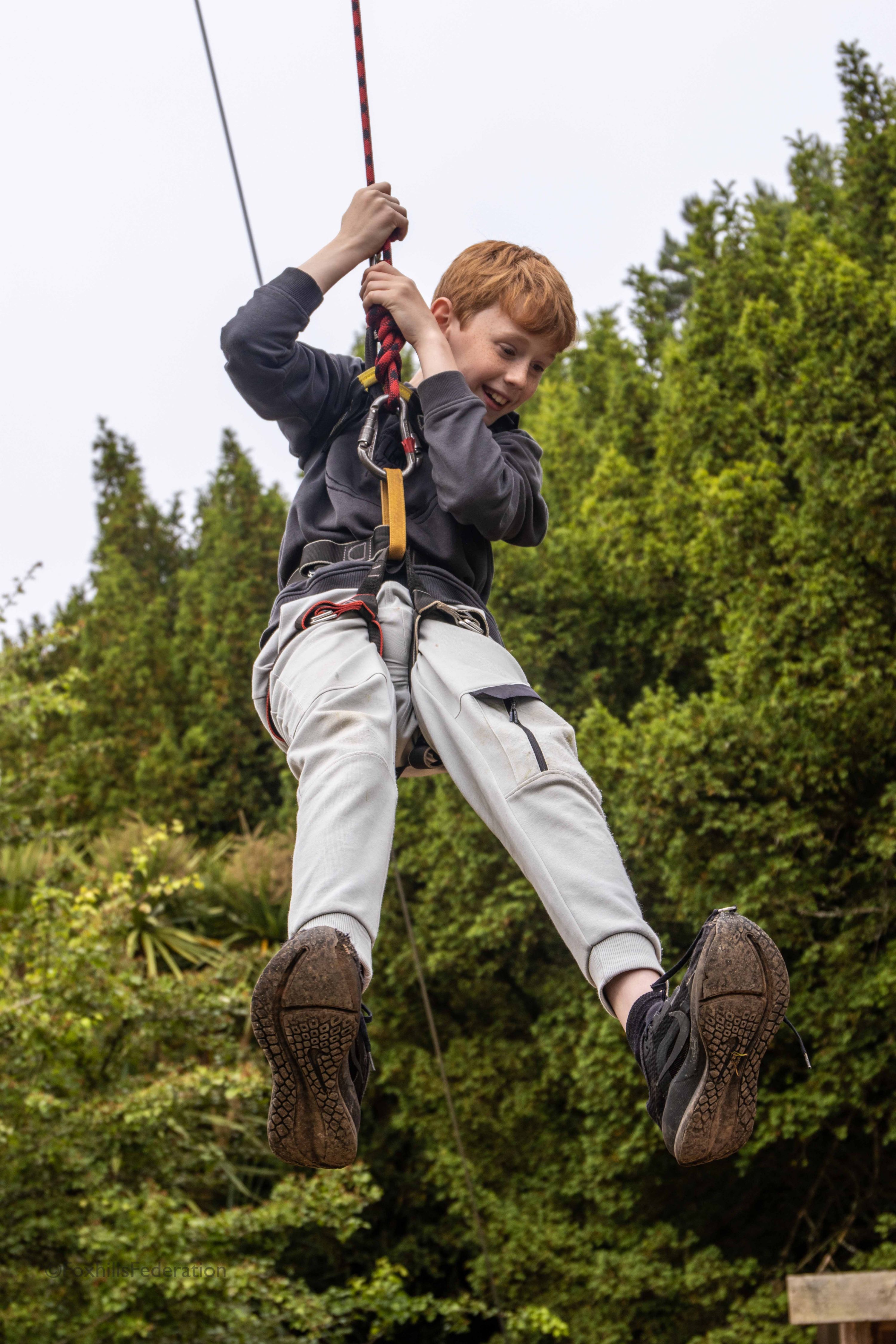 A boy hangs from a rope