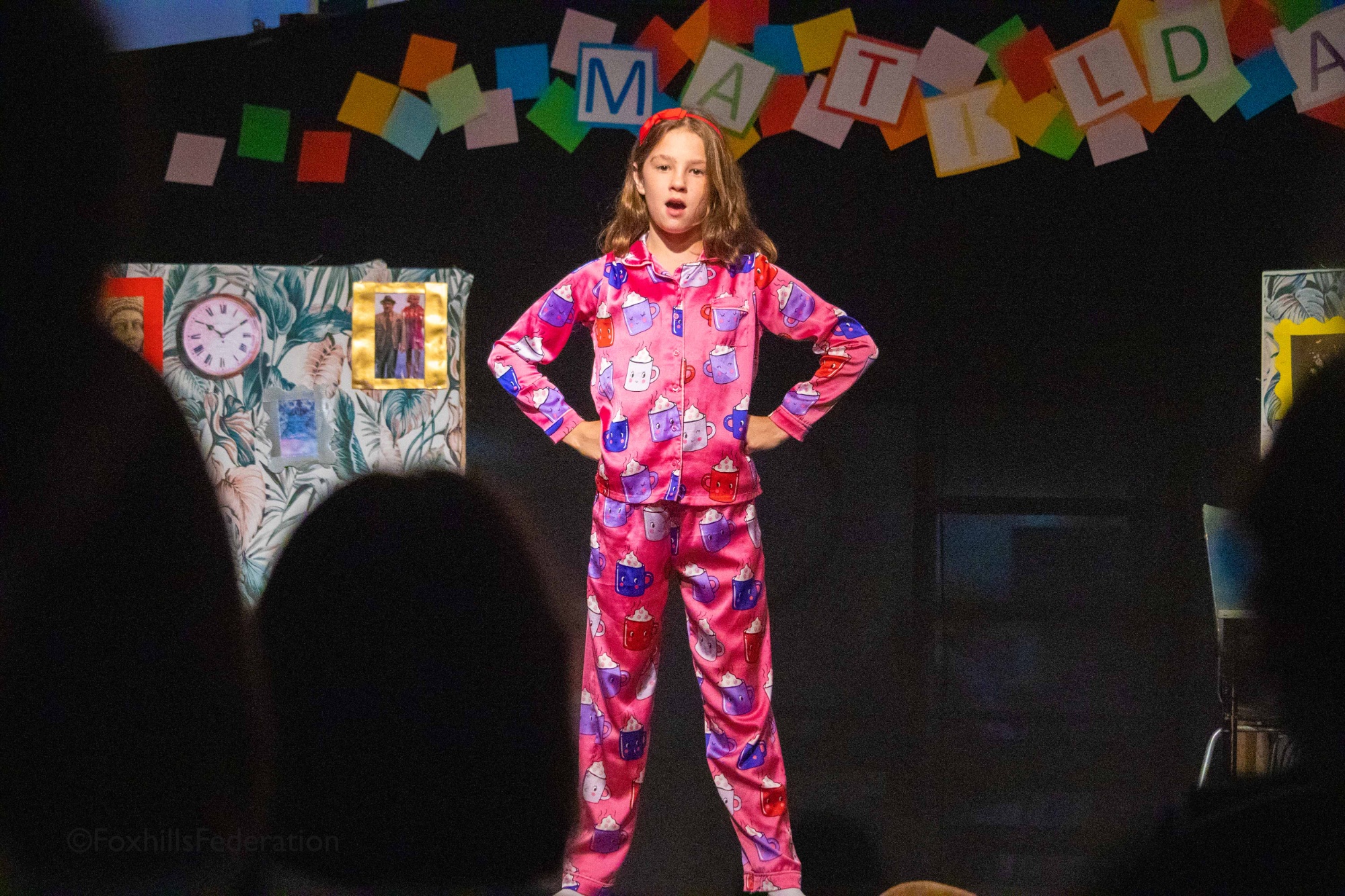 Matilda stands with her hands on her hips