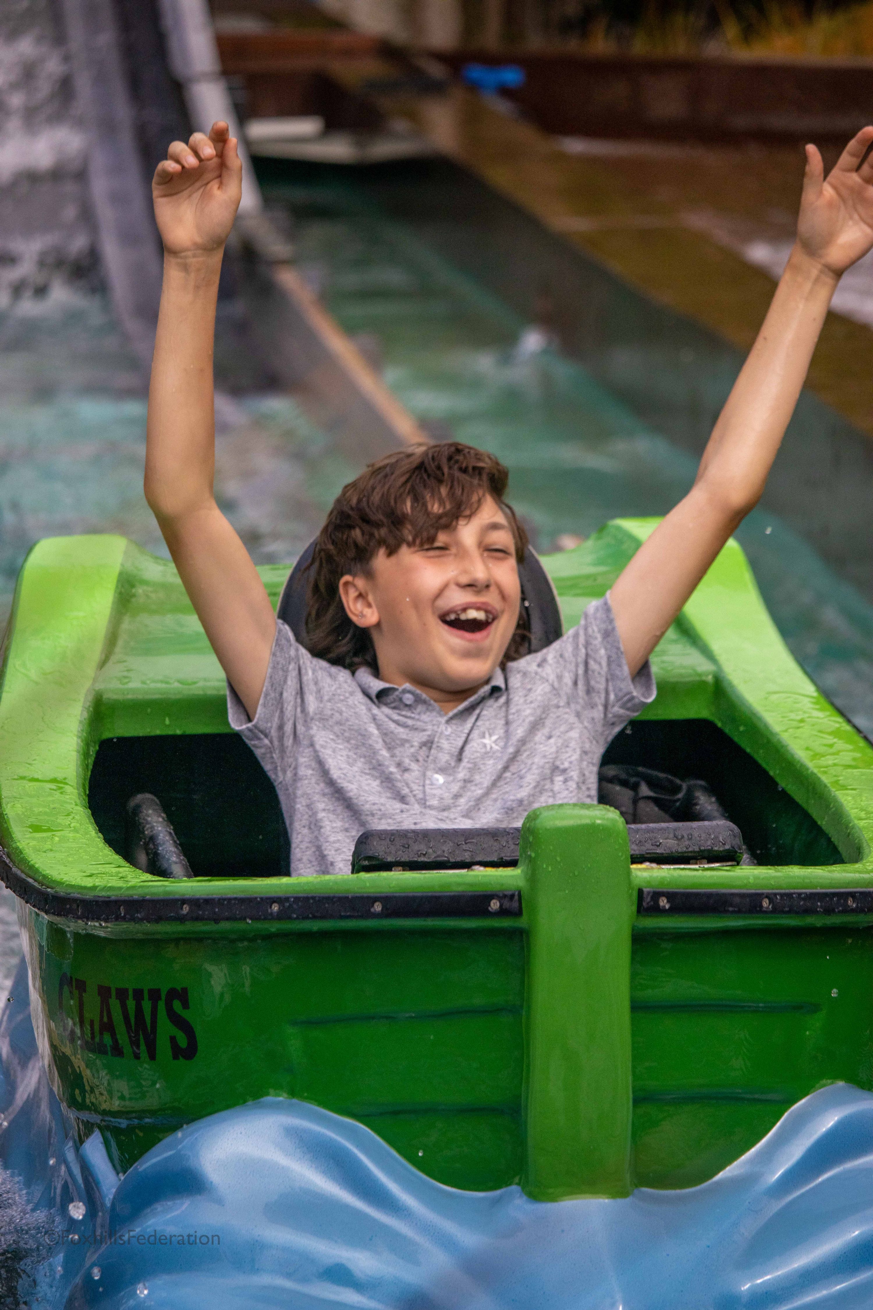 A boy is splashed on the log flume