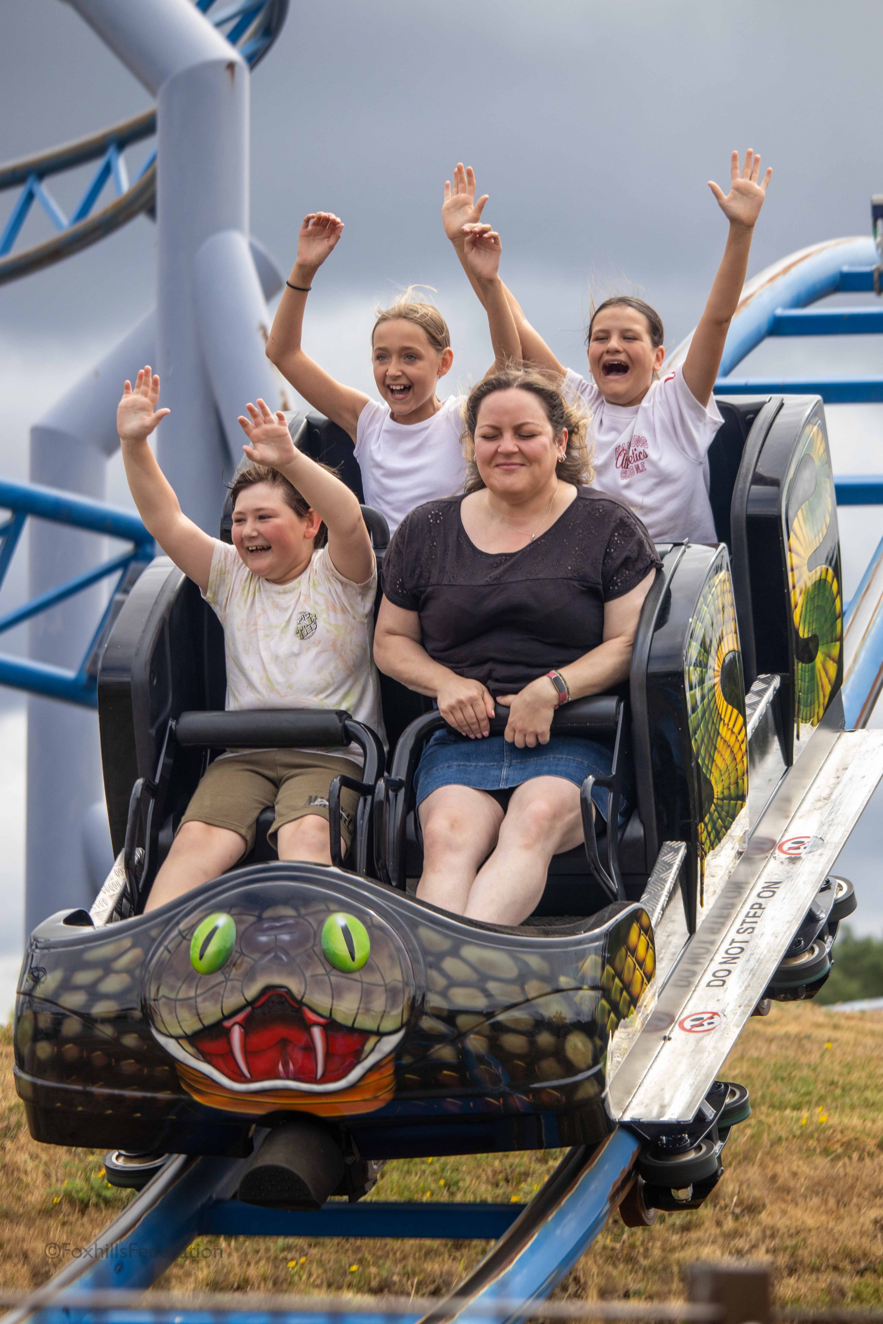 A group of children (and Miss D) scream on a rollercoaster