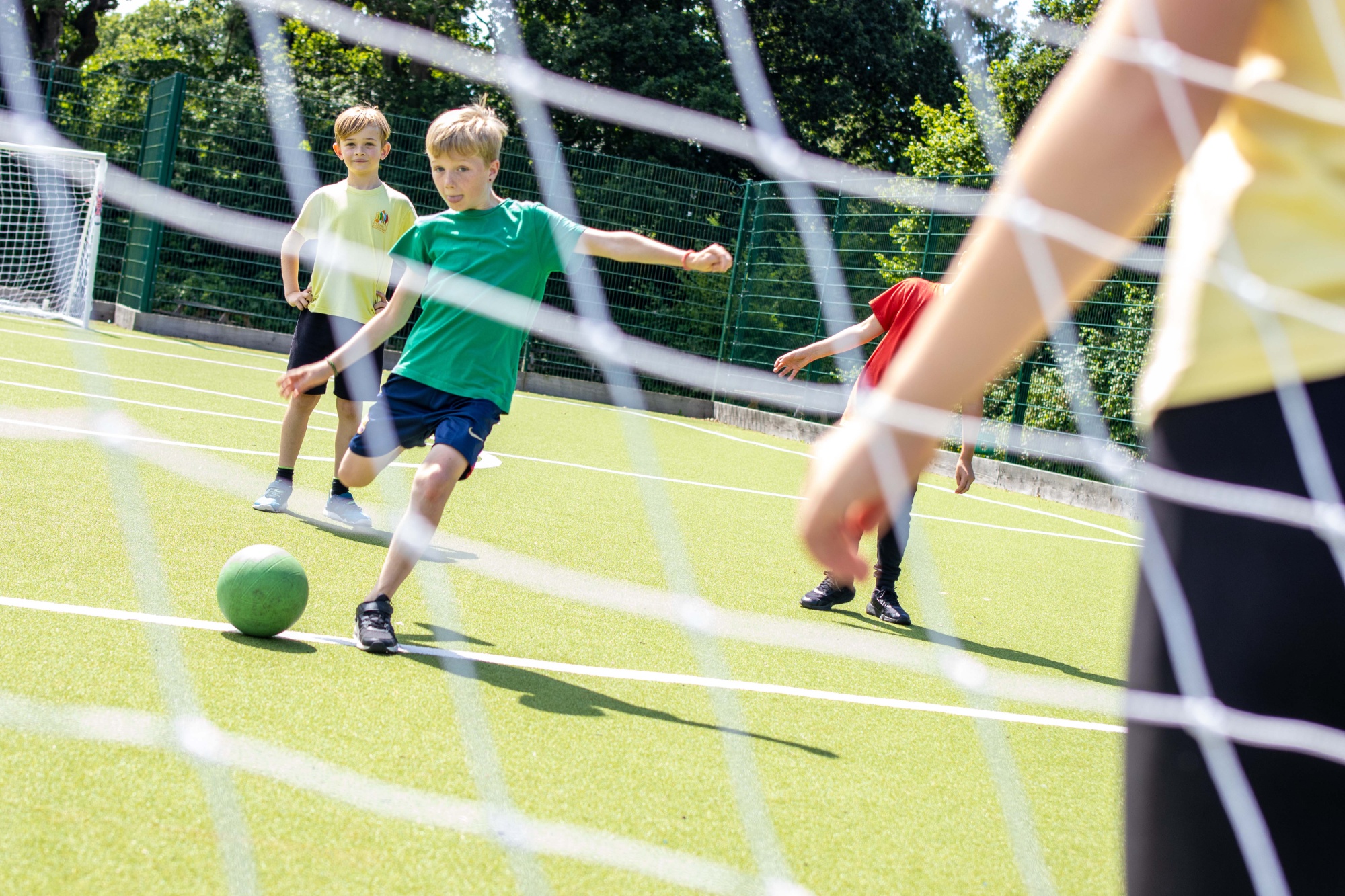 A boy kicks a football at a goal.
