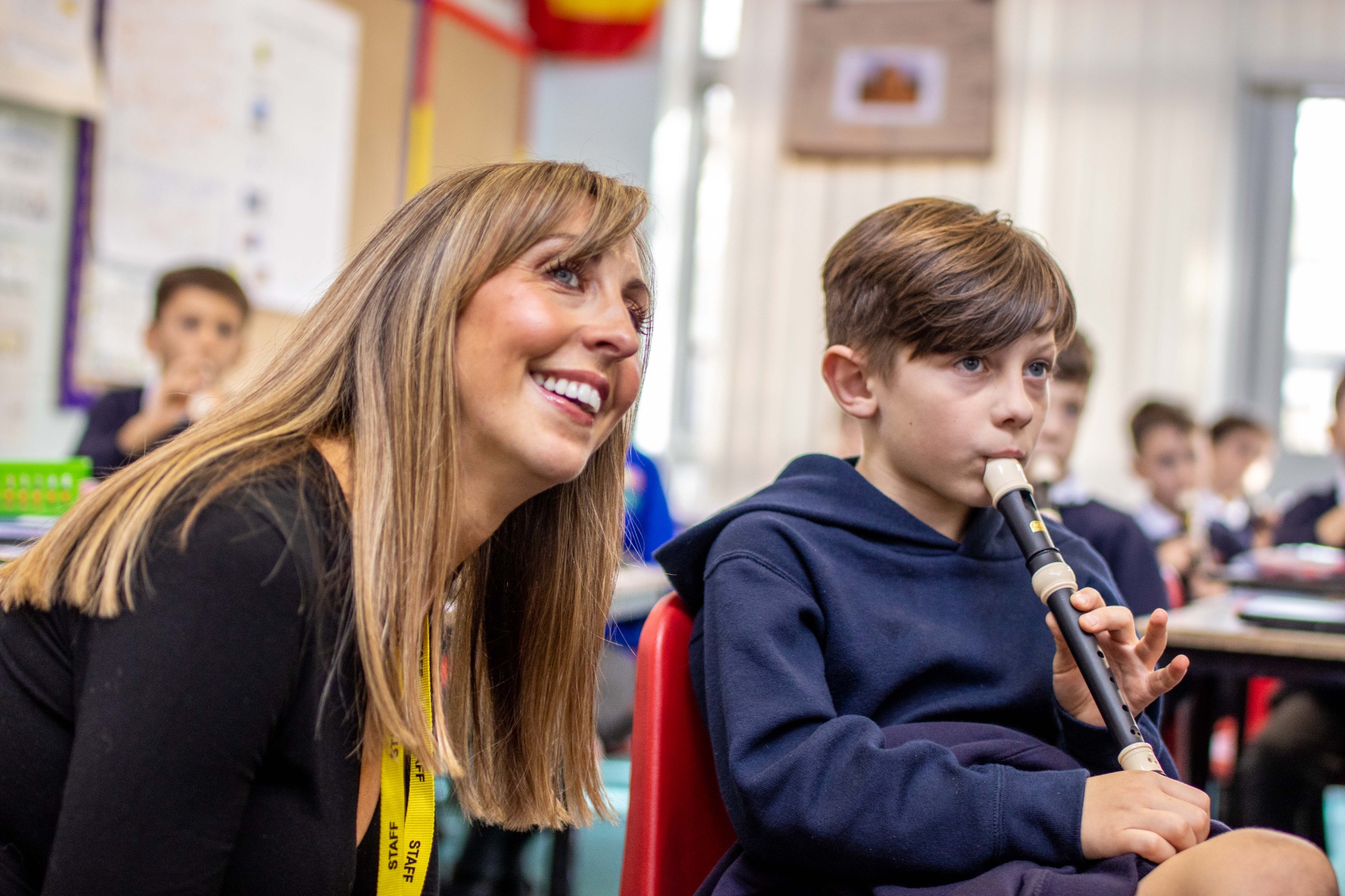 Headteacher Lucy Howe listening to a child playing the Recorder.