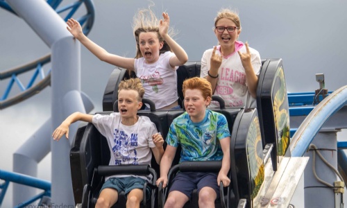 Four children scream on a roller coaster