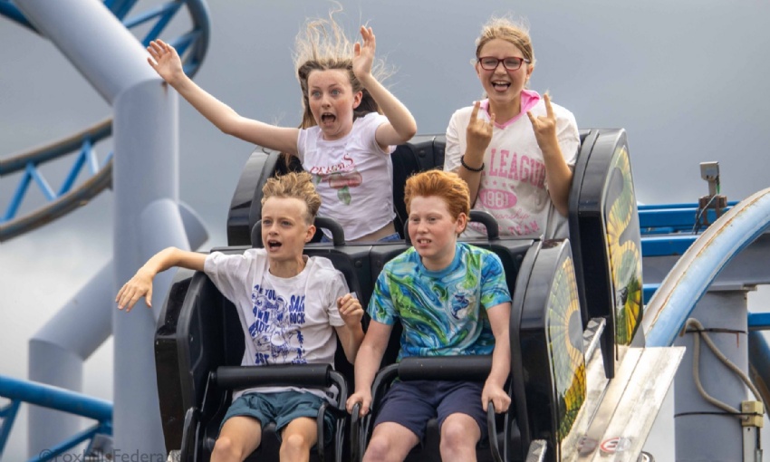 Four children scream on a roller coaster